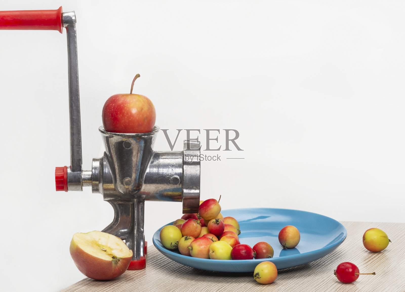 一个大苹果被放进绞肉机,变成了小苹果。孤立。笑话照片摄影图片