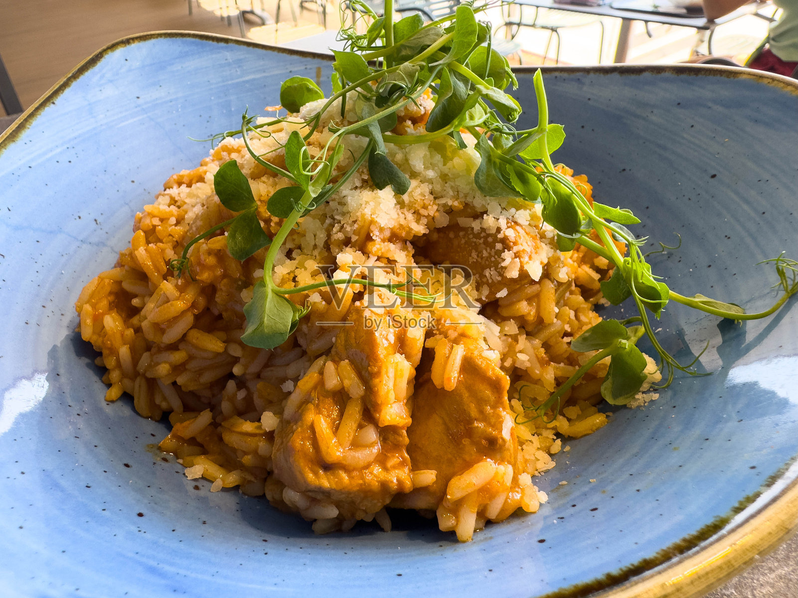 美味的鸡肉米饭菜肴,配有新鲜绿叶蔬菜和帕尔马干酪照片摄影图片