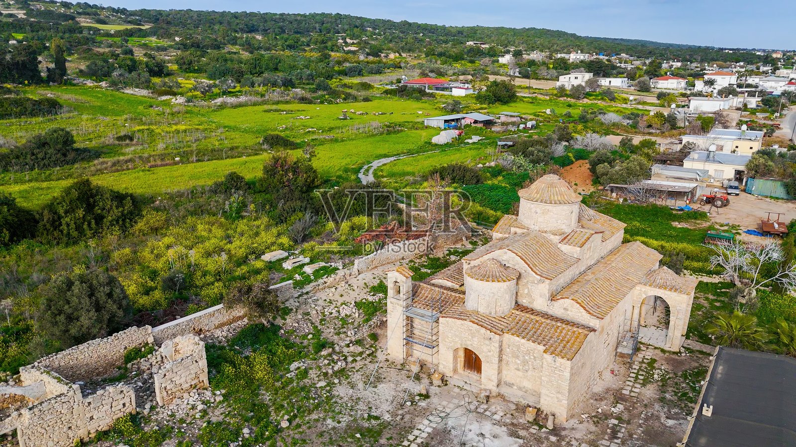 北塞浦路斯的帕纳基亚·卡纳卡里亚修道院的鸟瞰图,古老的拜占庭建筑被乡村风景和传统村庄建筑环绕,文化遗产与精神旅游概念照片摄影图片