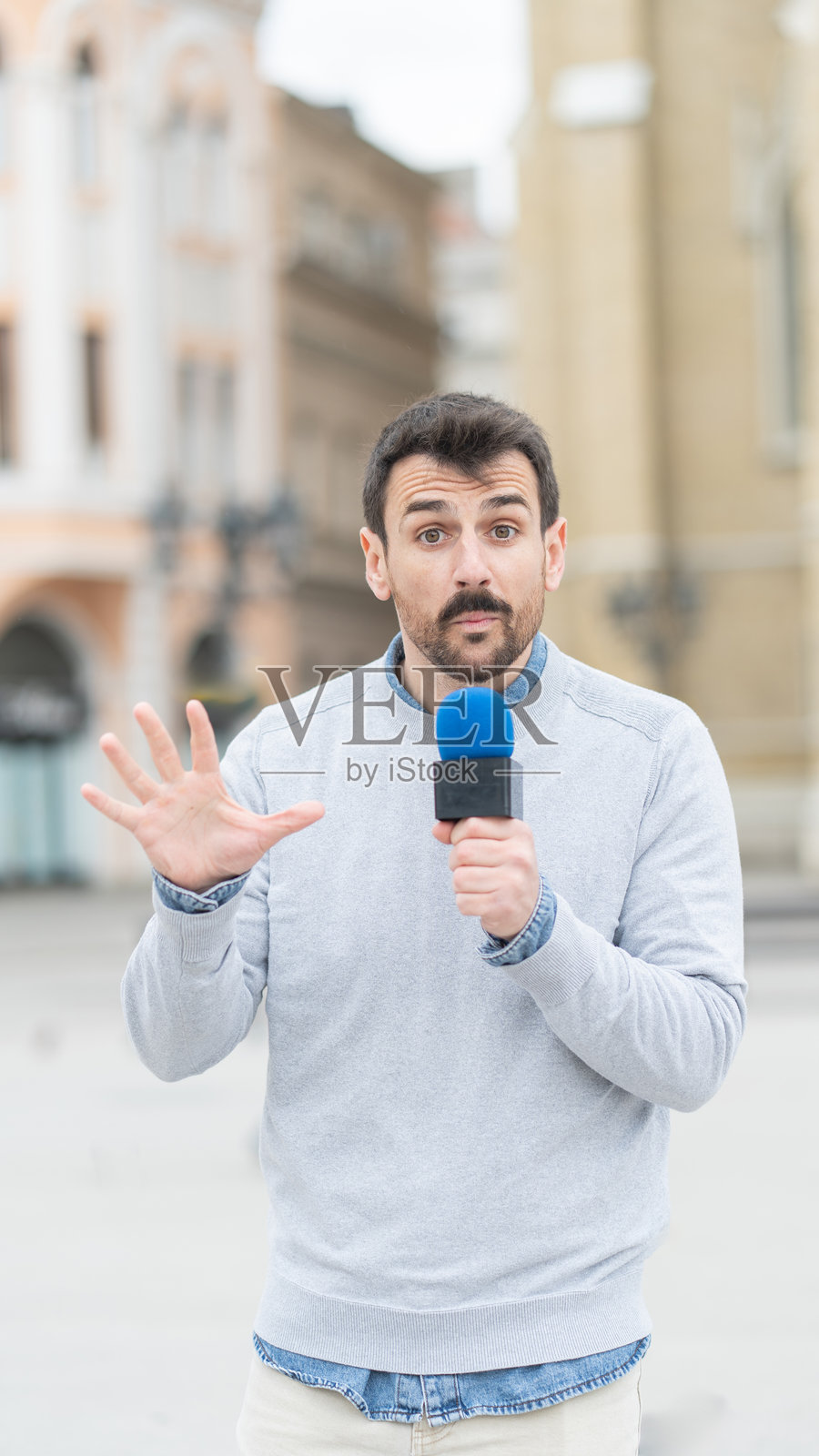 在热闹的城市环境中对着镜头讲话的男人照片摄影图片