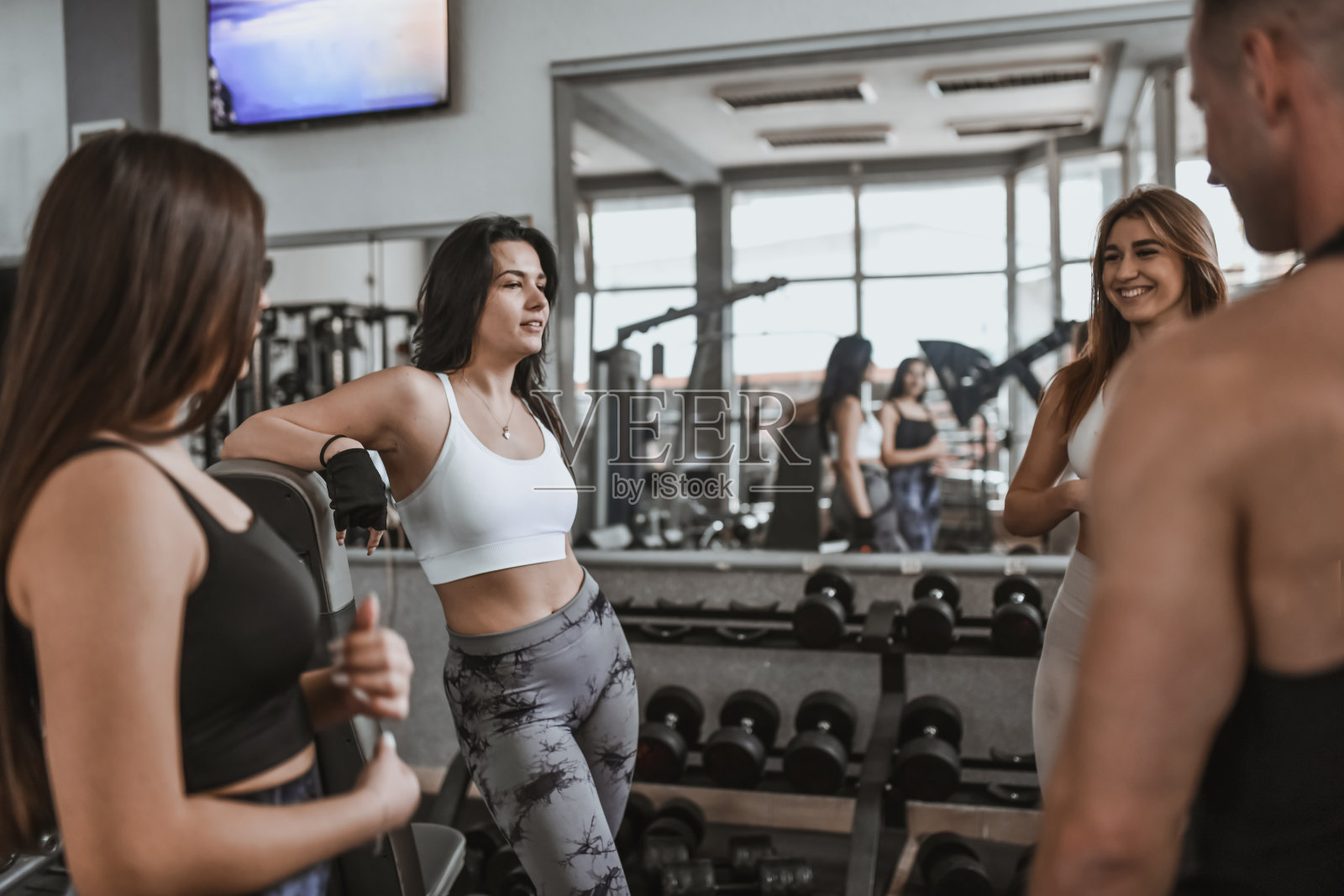 女性在辛苦锻炼后放松,和男教练聊天照片摄影图片