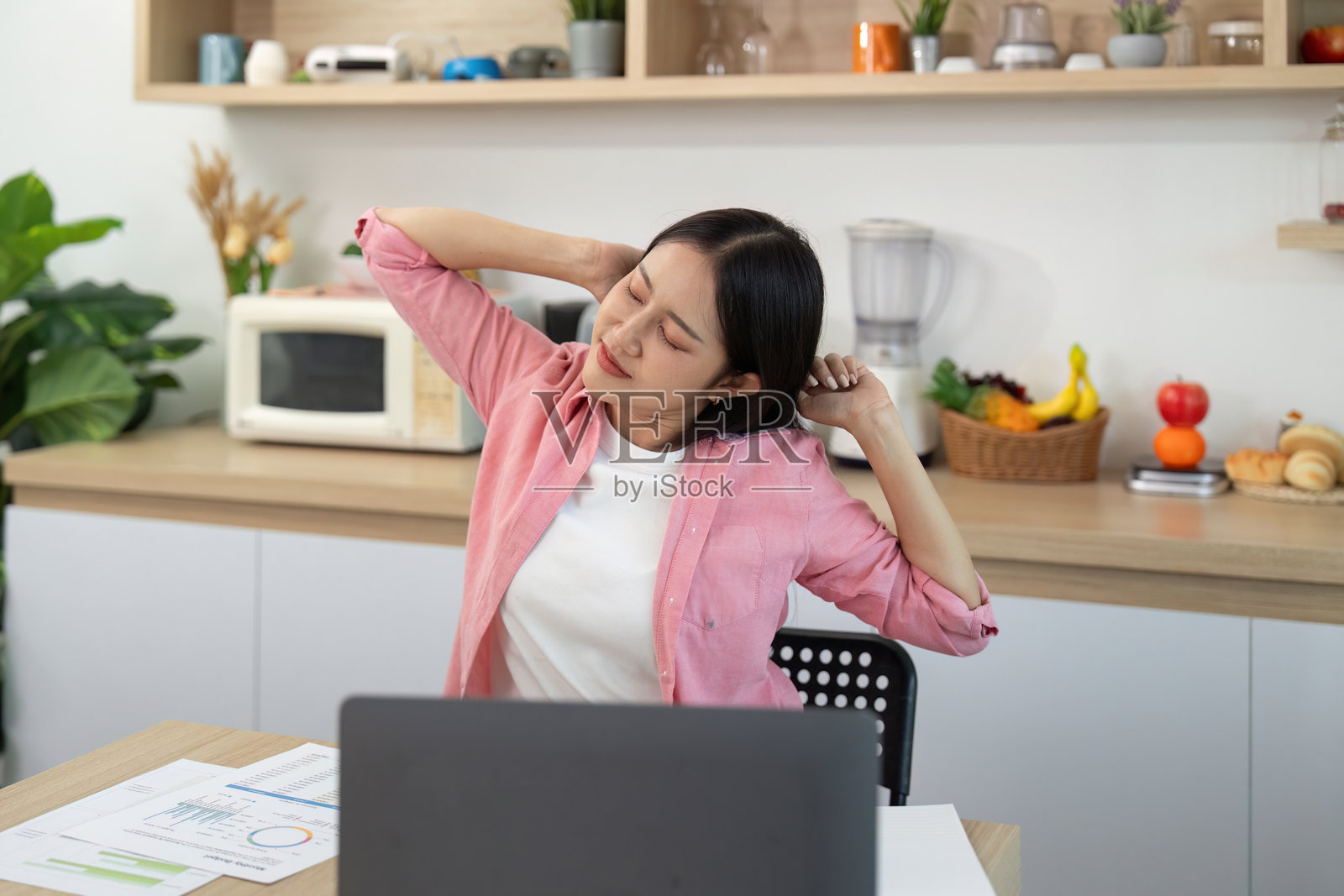 健康:年轻女性在家中远程工作时拉伸照片摄影图片