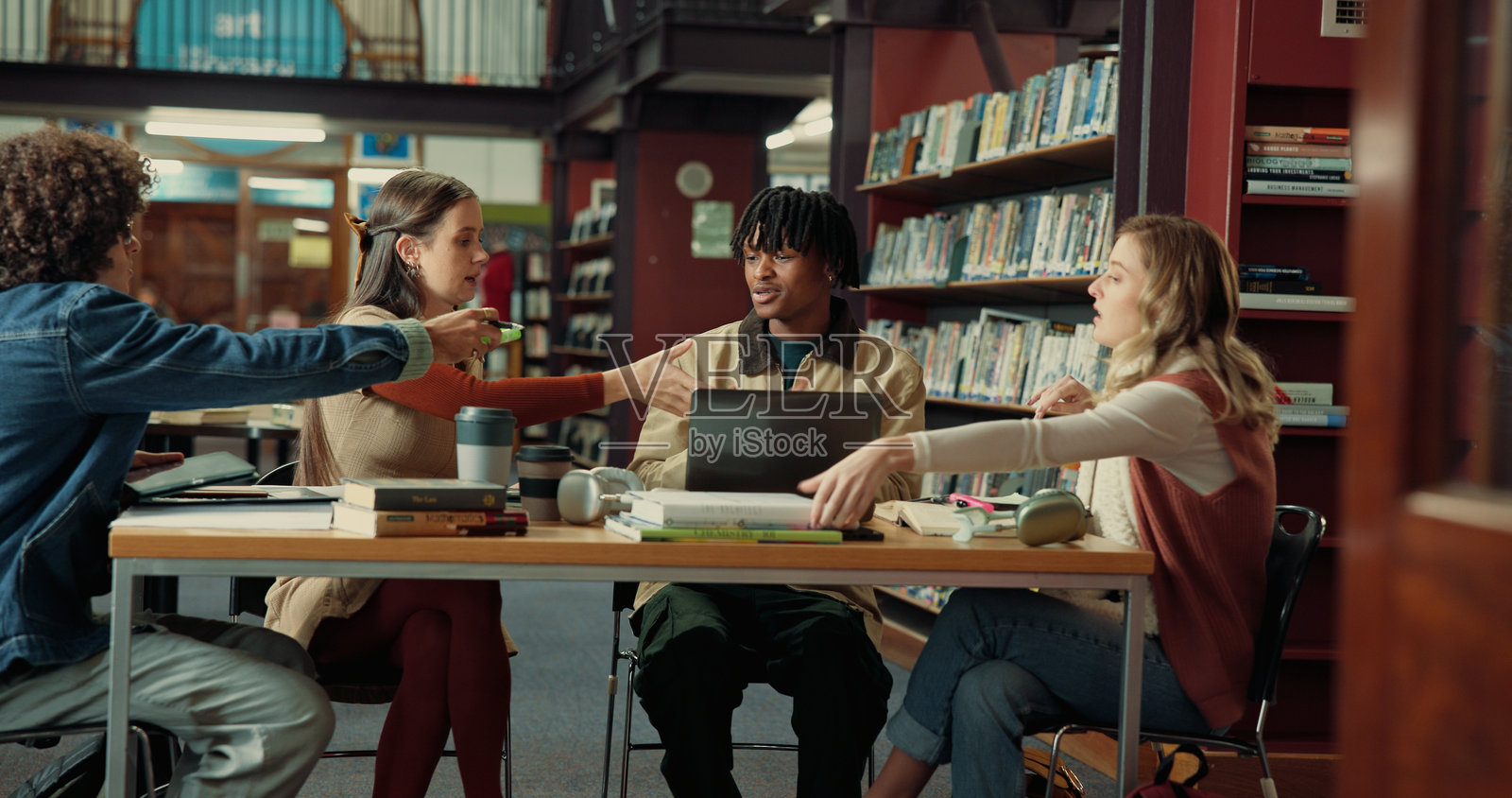 团队合作、学习小组和与朋友在图书馆进行研究项目的大学生活,帮助或教育。大学、作业资源和校园内的奖学金机会,适用于学校课程。照片摄影图片