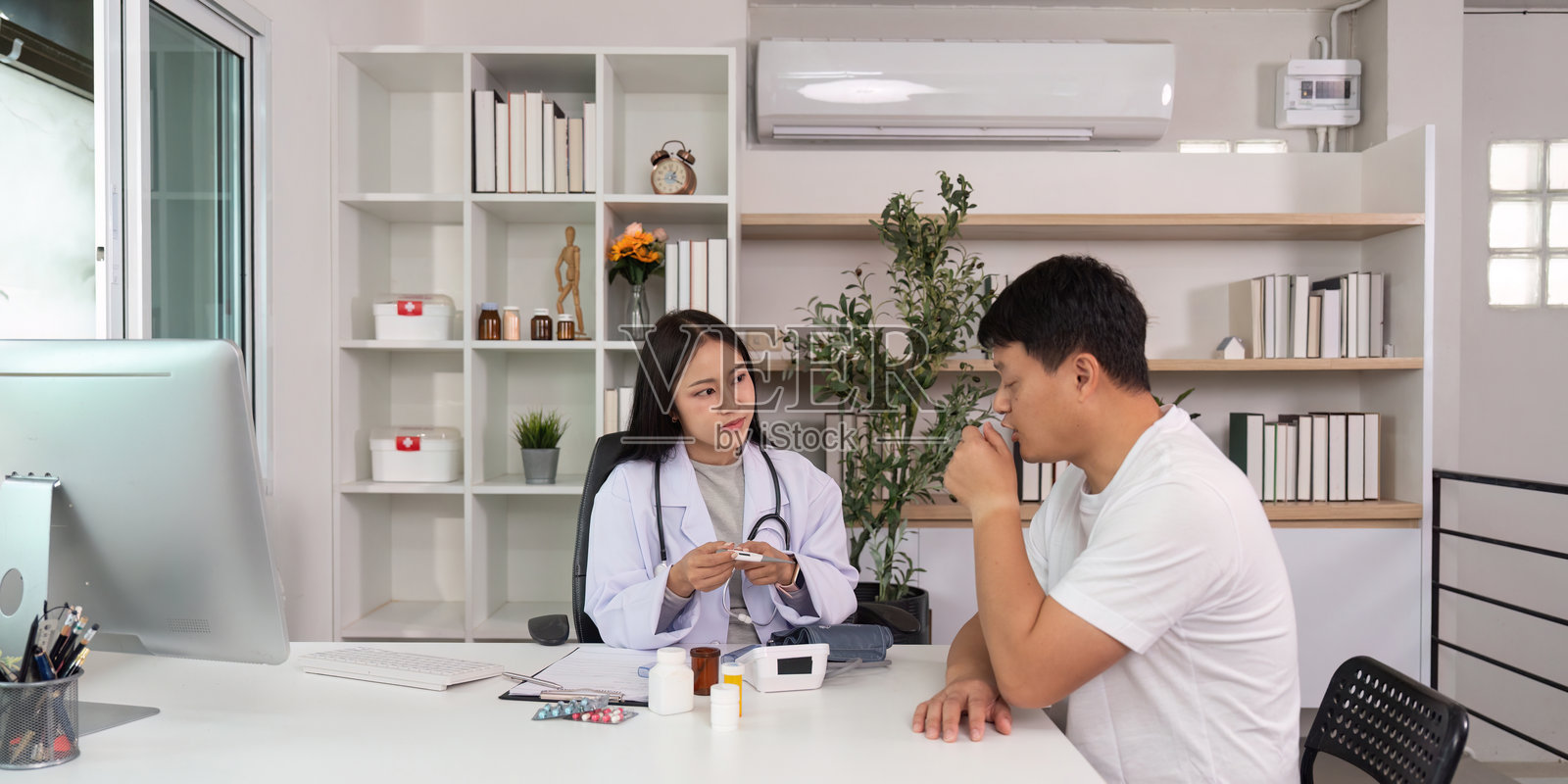 医疗咨询。医生在现代诊所与男性患者讨论治疗方案。照片摄影图片