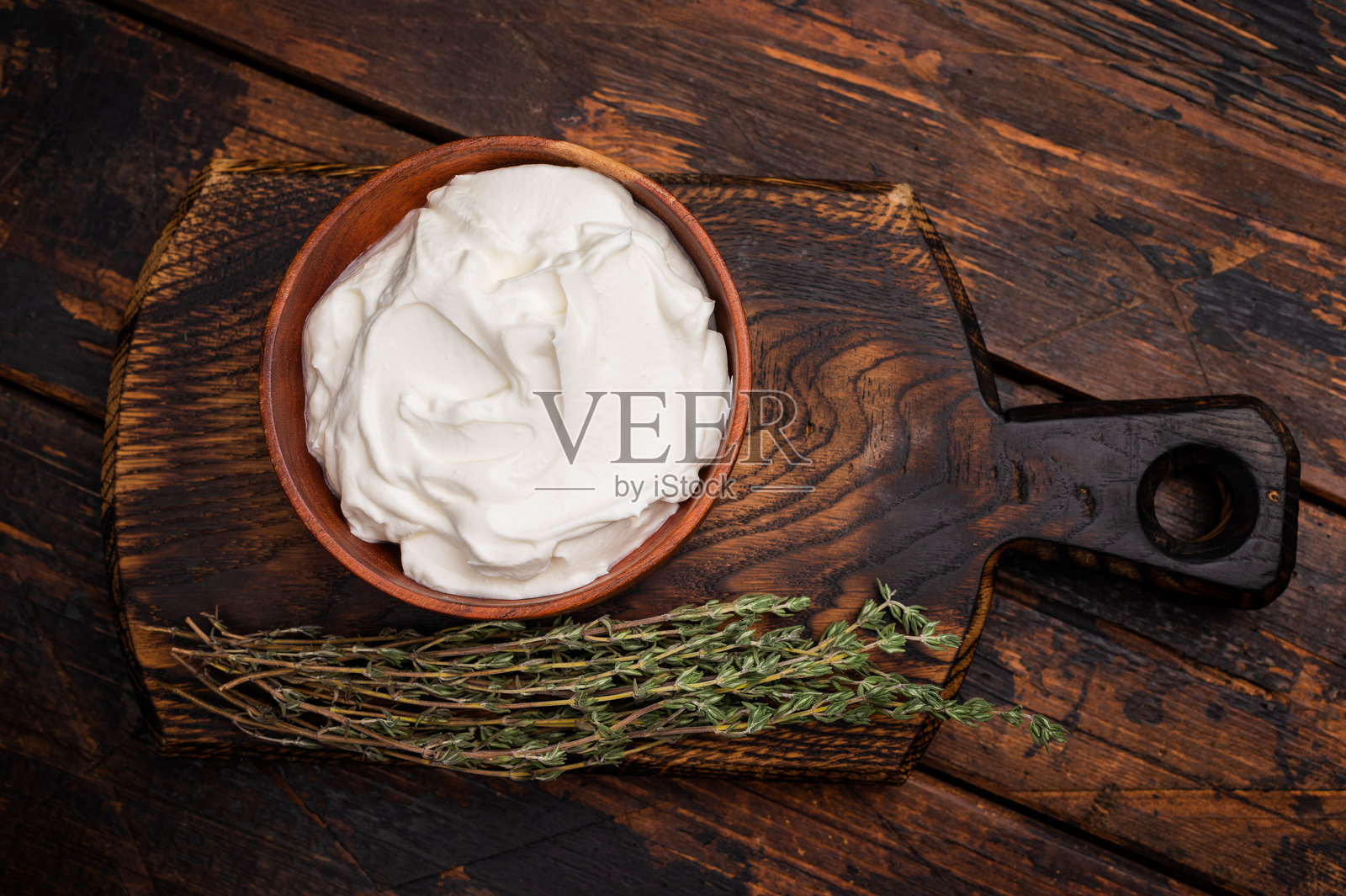 碗中盛有新鲜酸奶油的调味酱。木质背景。俯视图。照片摄影图片