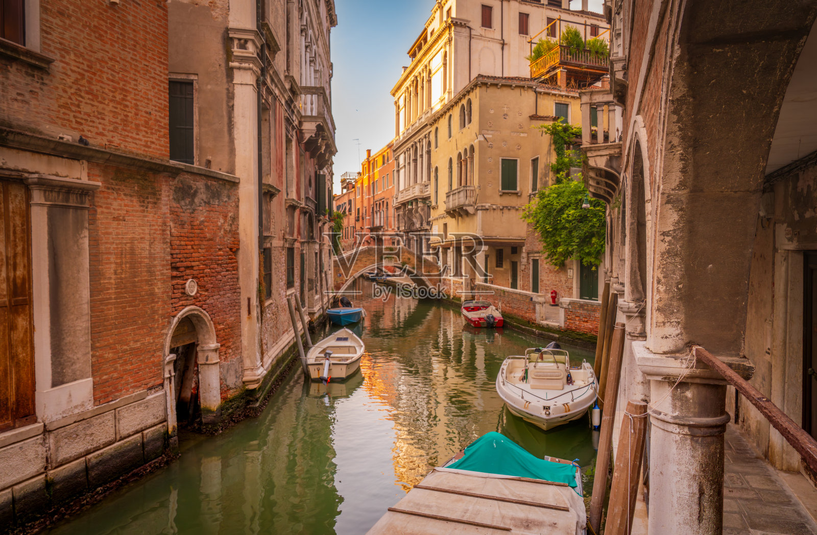 威尼斯运河与日落时分的石头人行桥照片摄影图片