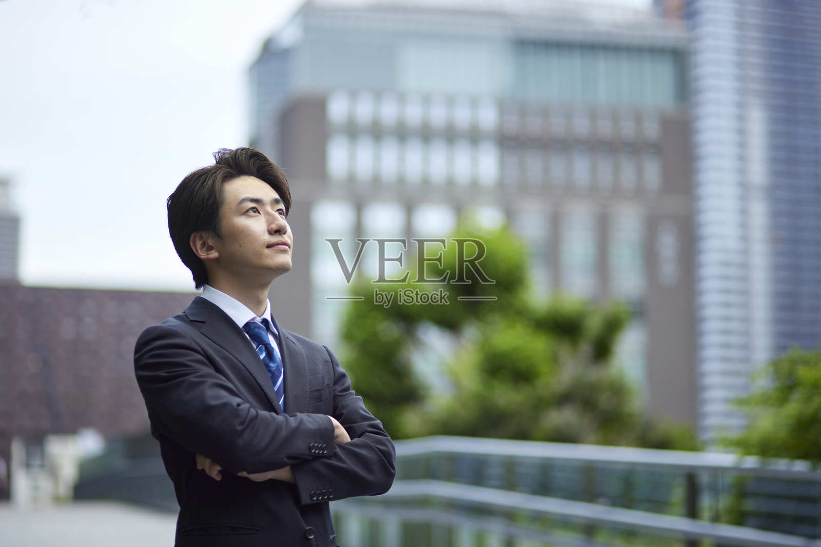 一位穿着西装的日本男子在商业区凝视远方照片摄影图片