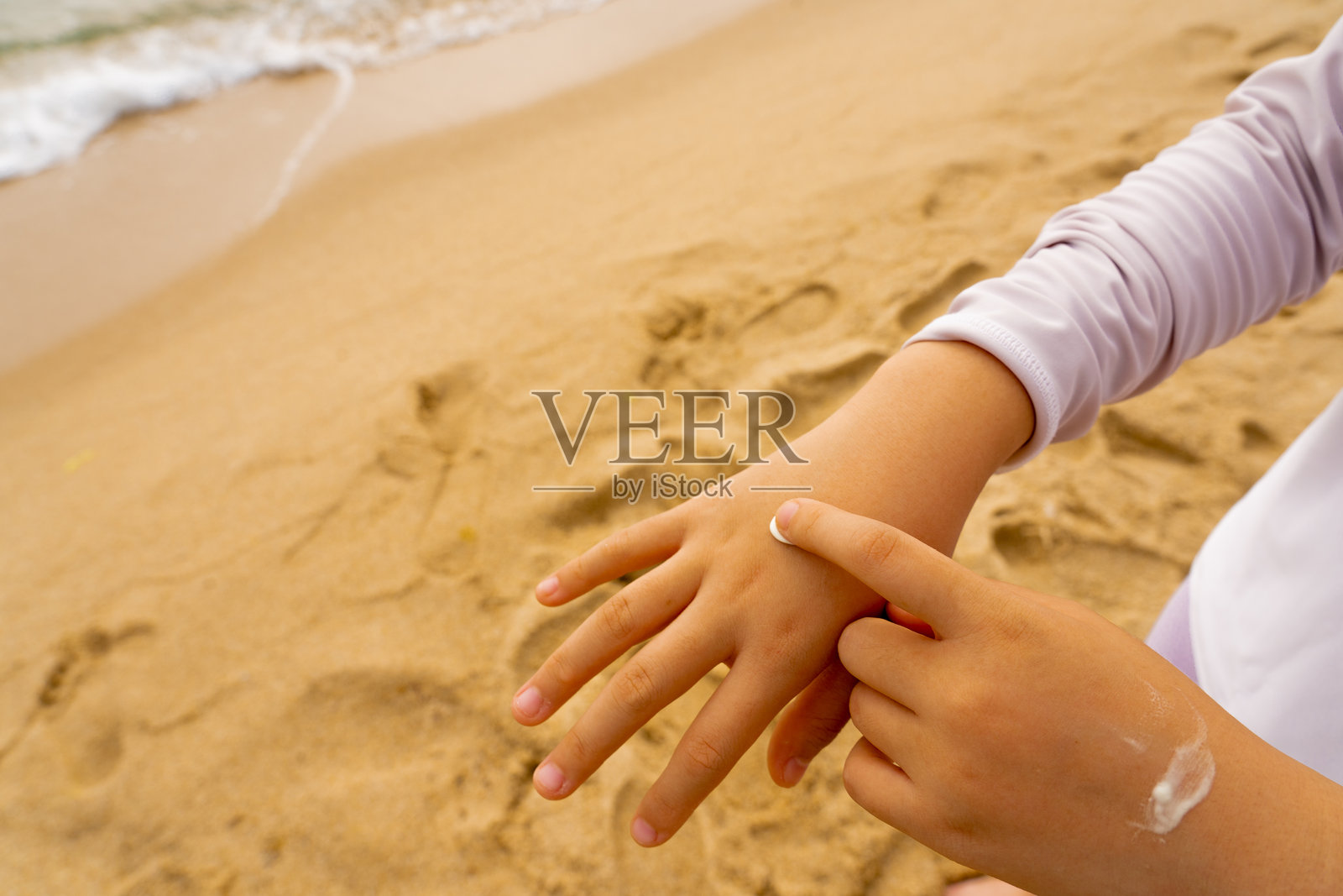 孩子在手上涂抹防晒霜照片摄影图片