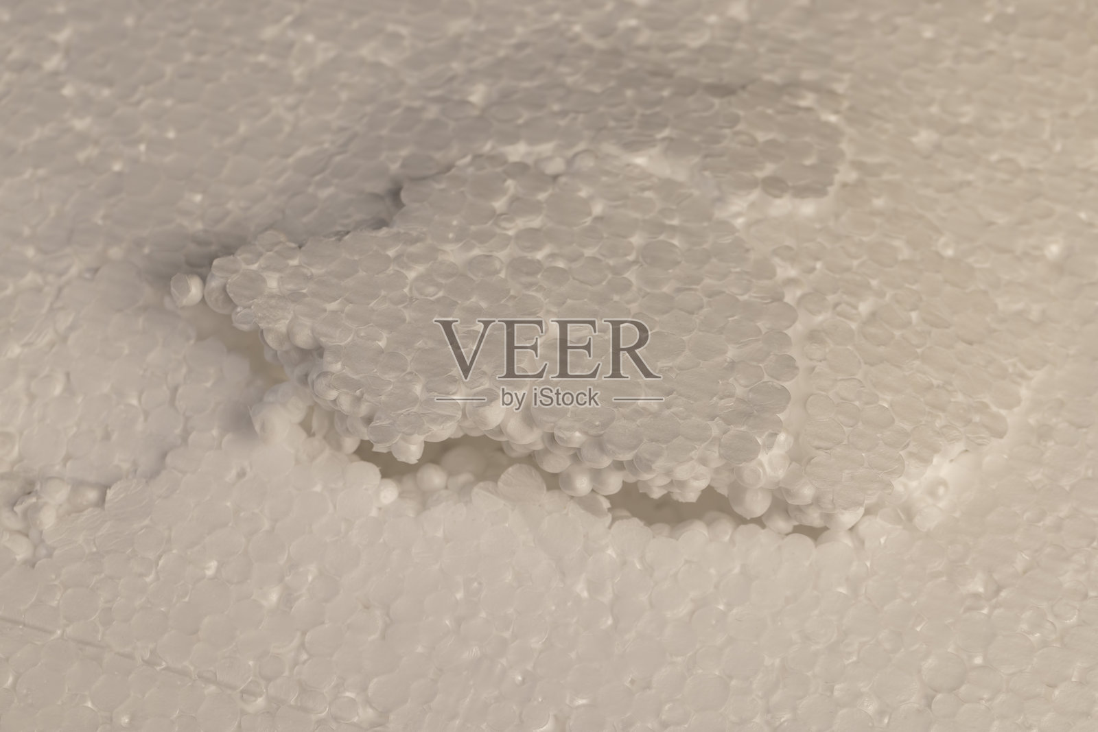 用于运输或建筑绝缘的白色泡沫,泡沫中的凹陷和损坏,由大量球形颗粒连接在一起的白色泡沫照片摄影图片