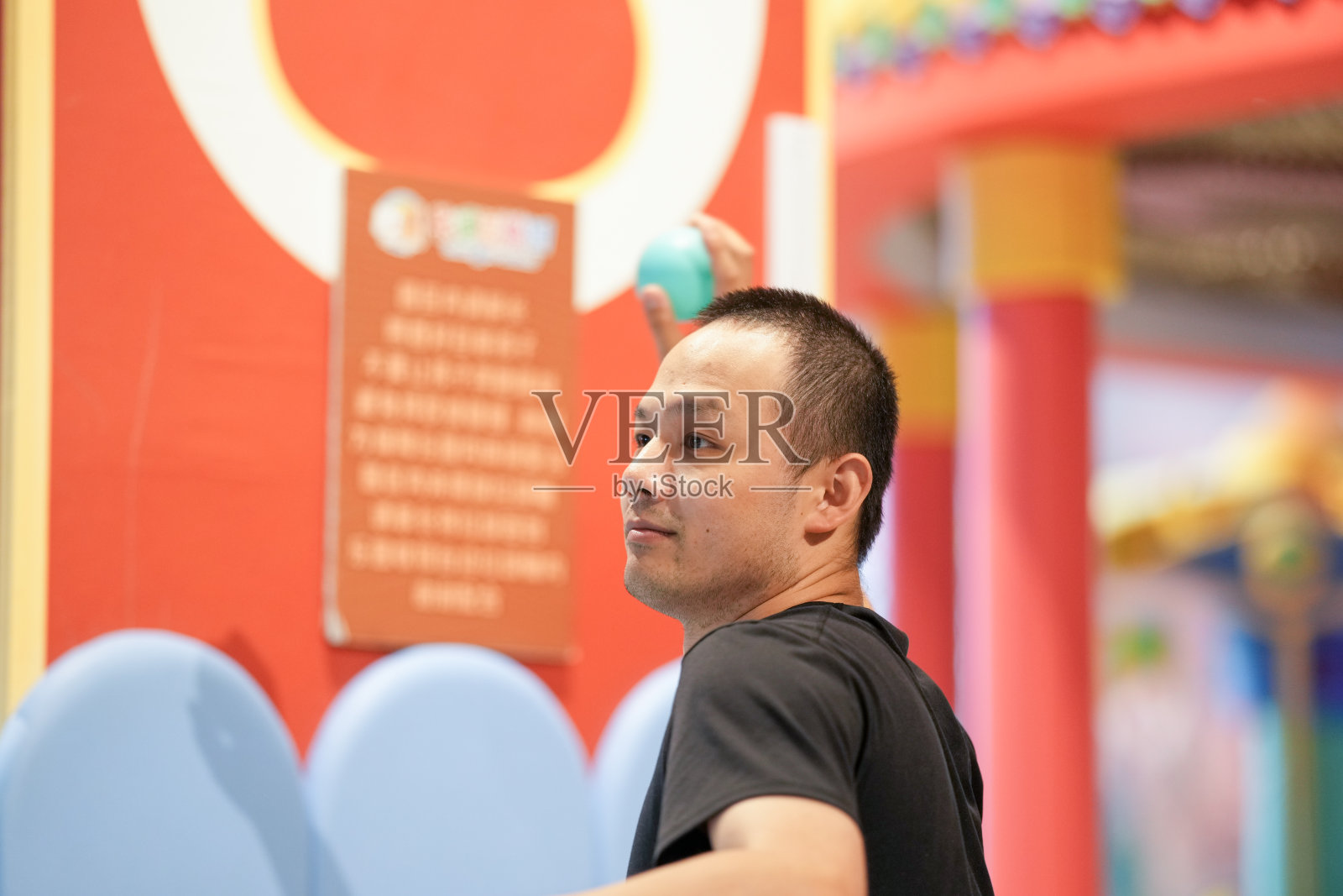 上海市虹口区的三十多岁中国成年人在室内游乐区的塑料球池中玩耍。春季。照片摄影图片