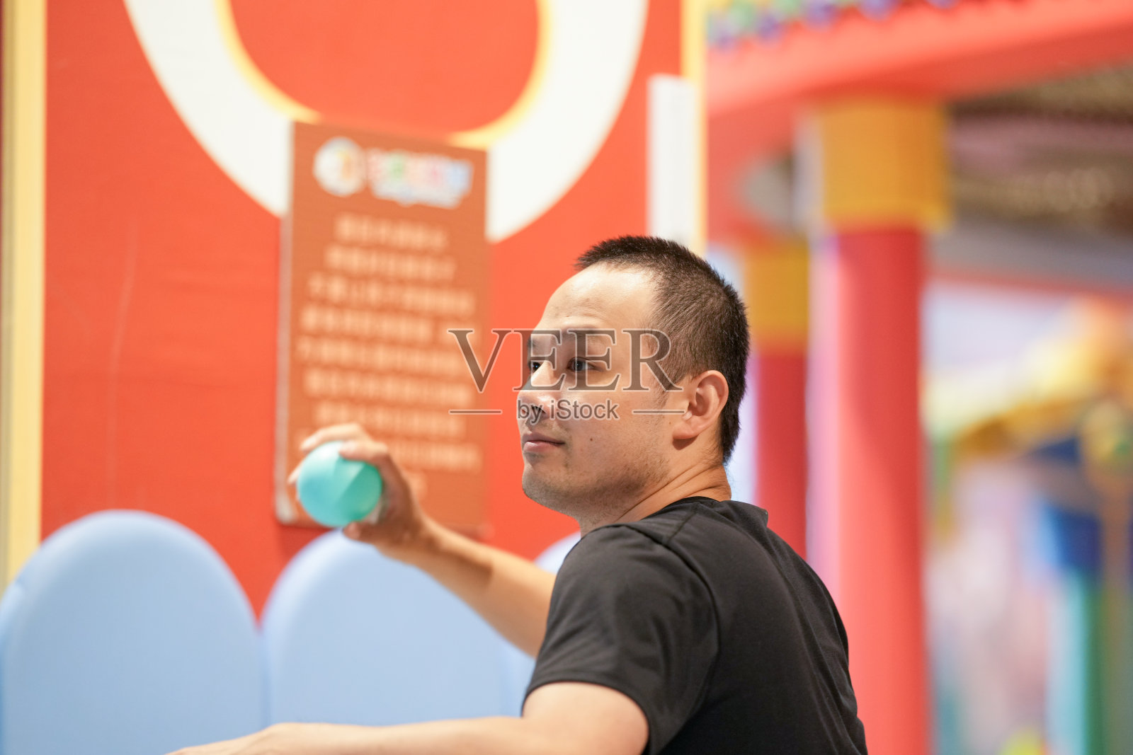 上海市虹口区的三十多岁中国成年人在室内游乐区的塑料球池中玩耍。春季。照片摄影图片