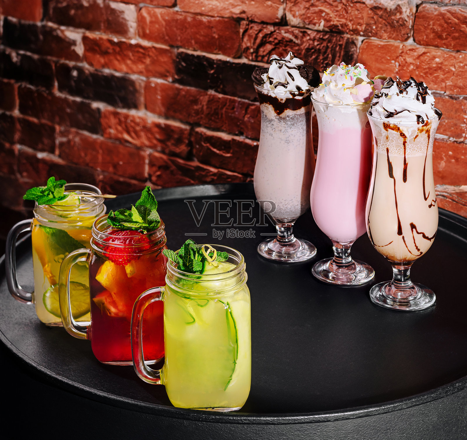 时尚桌子上展示的清爽饮品,背景是砖墙。照片摄影图片