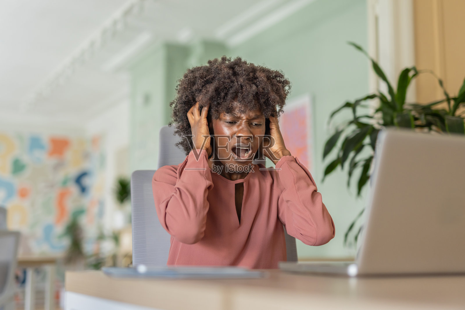 一位卷发女性在明亮的空间中表达沮丧情绪照片摄影图片