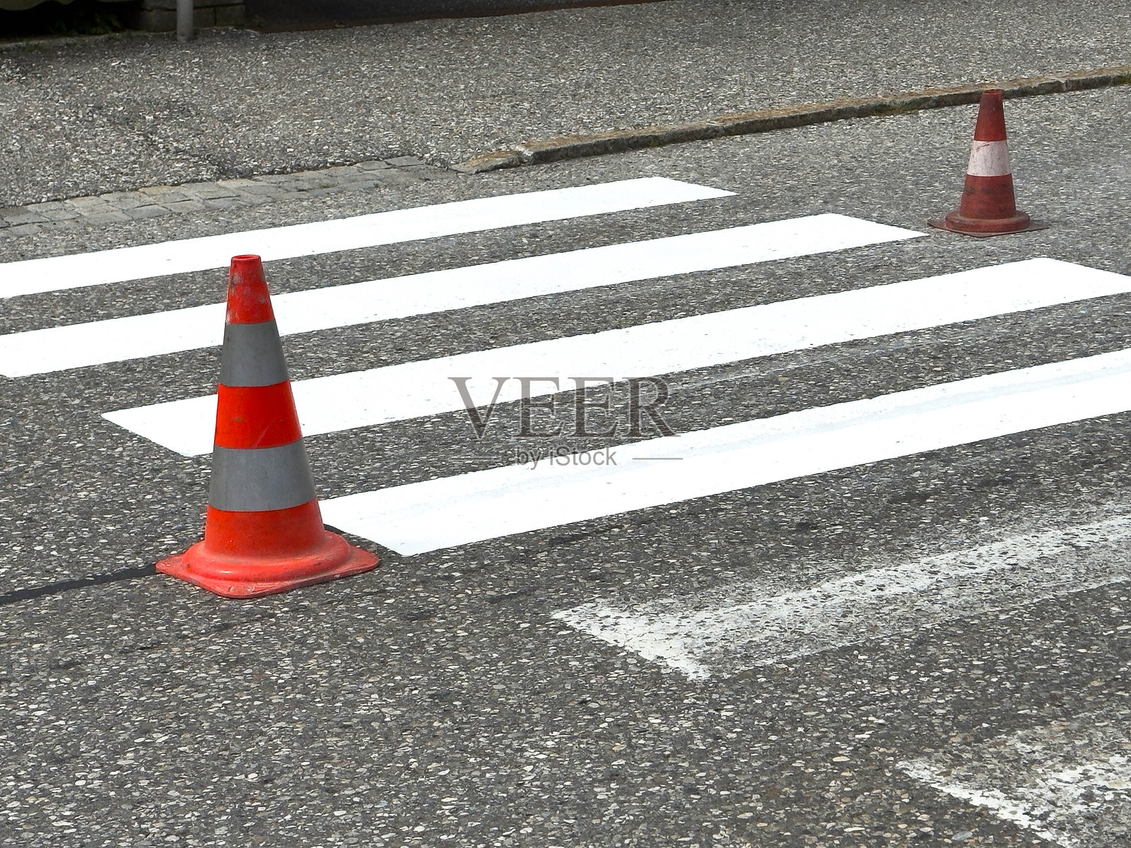 空荡荡的人行横道上有交通锥,铺设在沥青路面上照片摄影图片