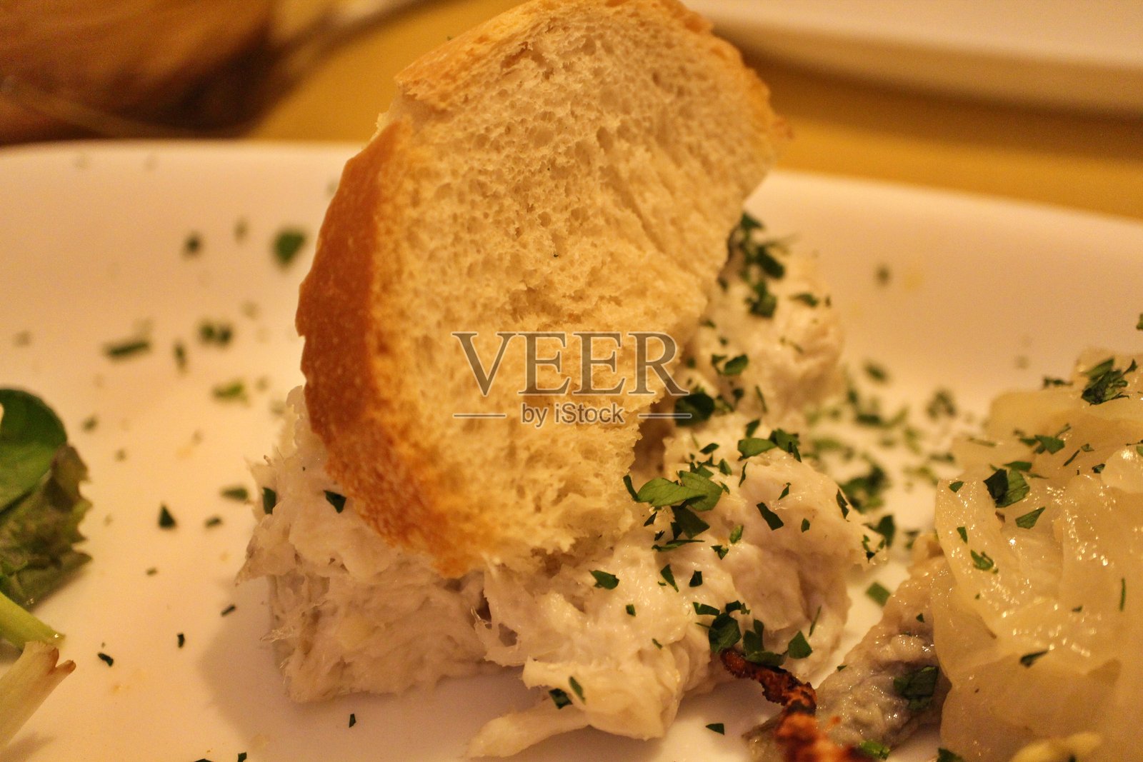 意大利美食:威尼斯的咸鳕鱼(干咸鳕鱼)配面包照片摄影图片