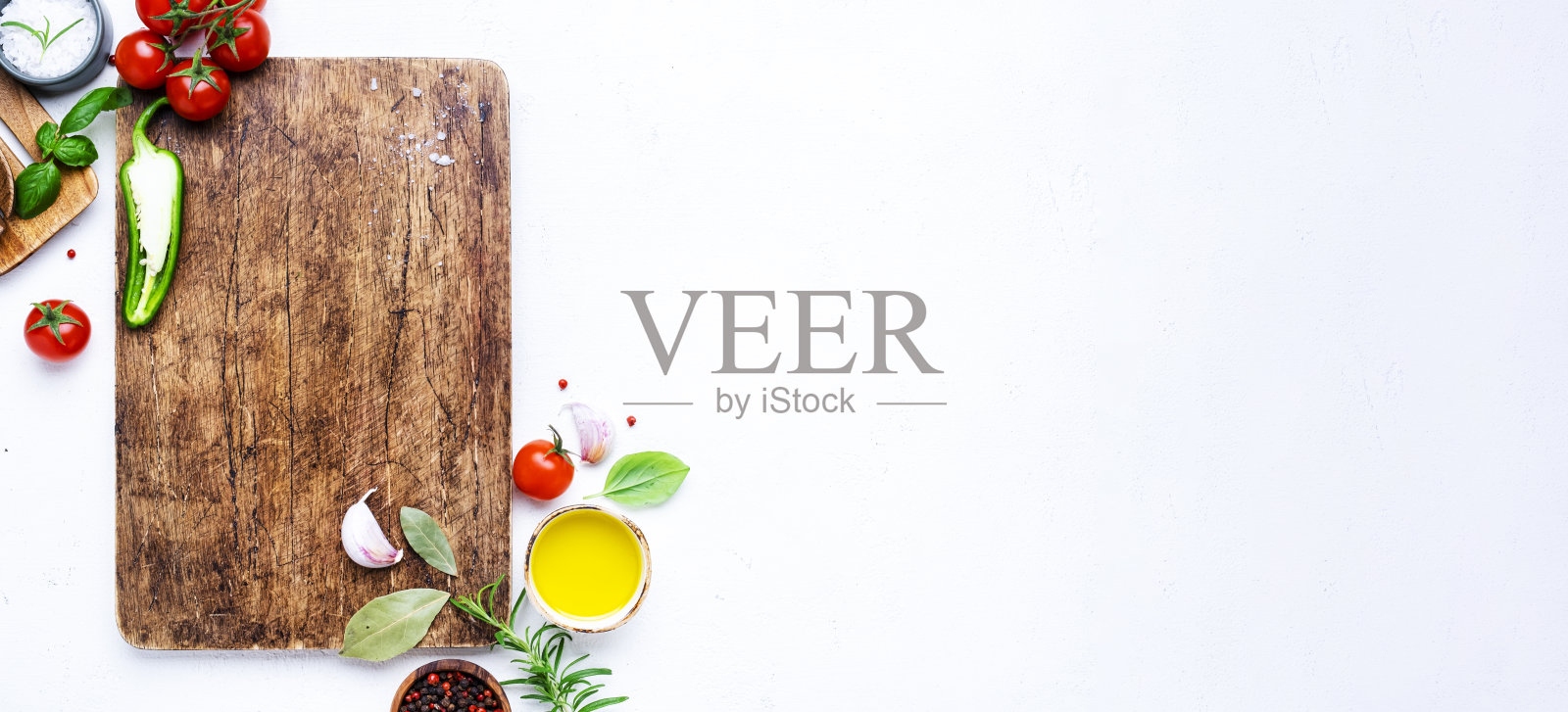 食品和烹饪背景,香料,草药,木质切菜板上的墨西哥胡椒,俯视图。胡椒粒,迷迭香,罗勒,西红柿和其他食材。照片摄影图片