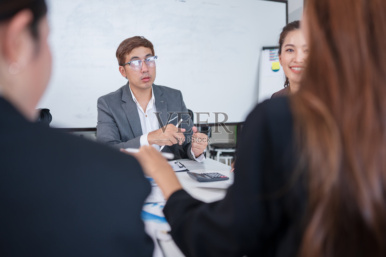 一群亚洲商务人士在办公室开会并展示工作照片摄影图片