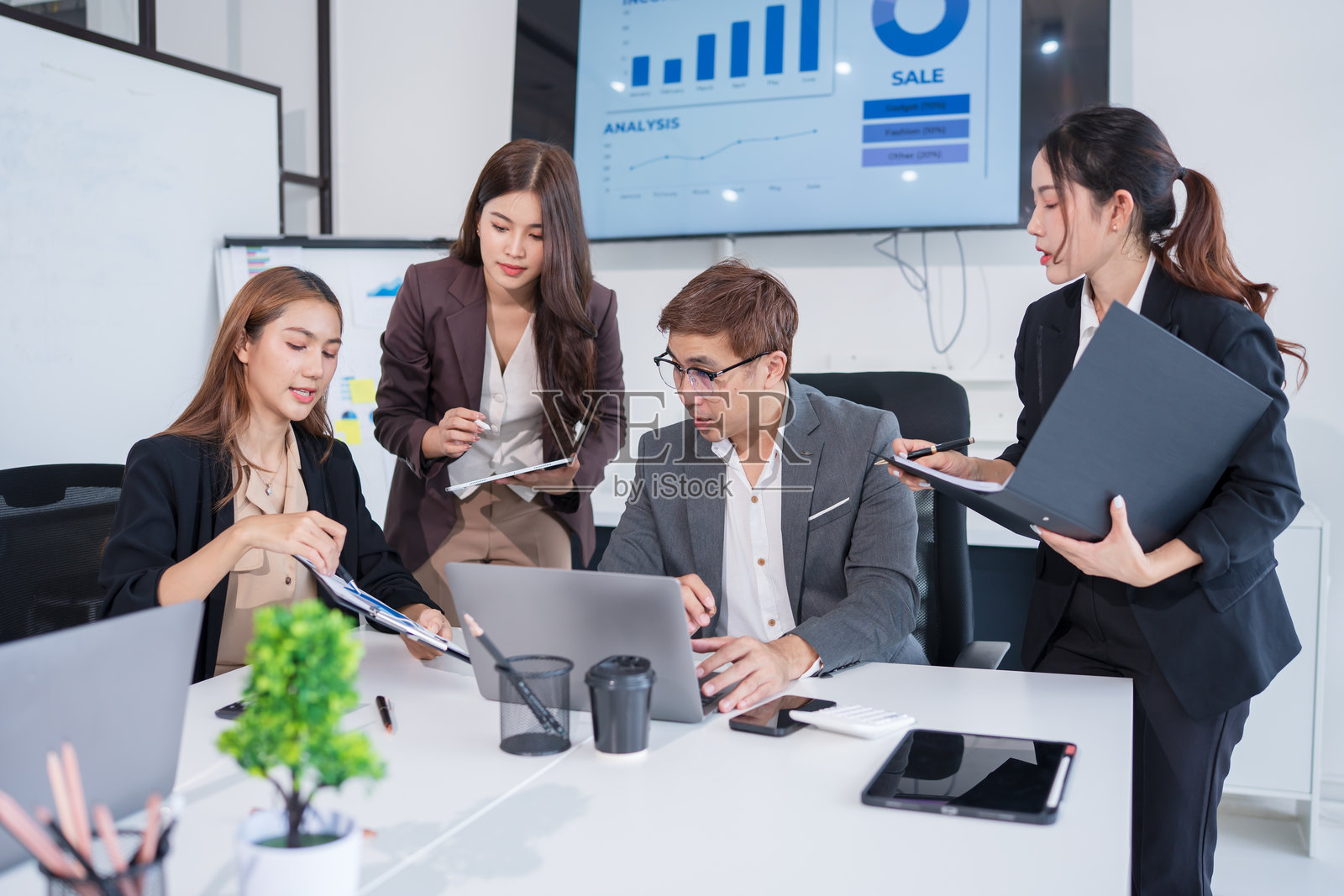 一群亚洲商务人士在办公室开会并展示工作照片摄影图片