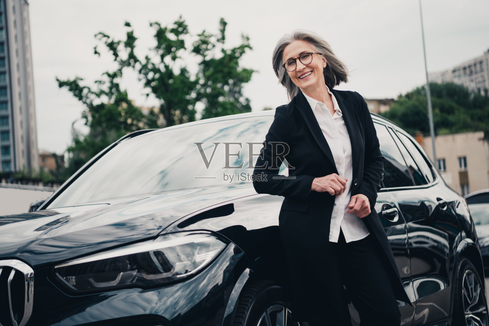 自信的成熟的女商人在城市白天的环境中与汽车合影照片摄影图片