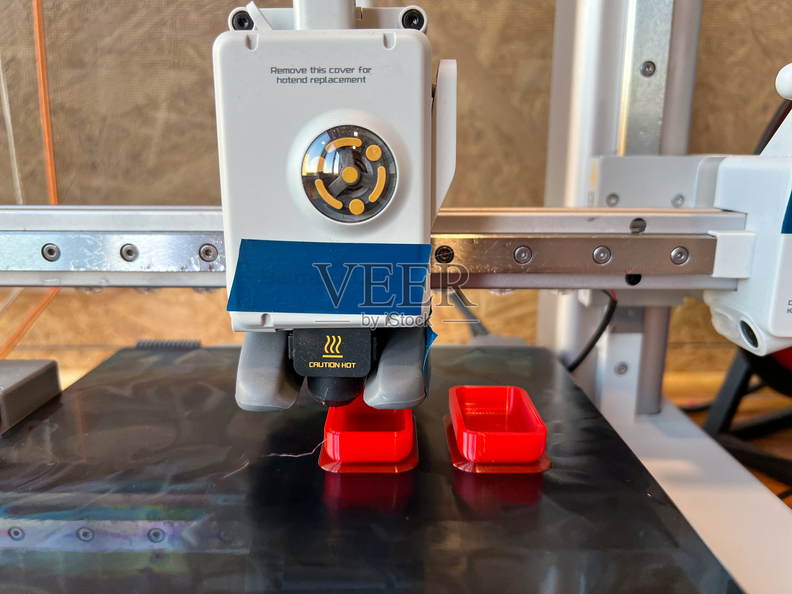 3D打印机在车间中制造红色塑料零件照片摄影图片