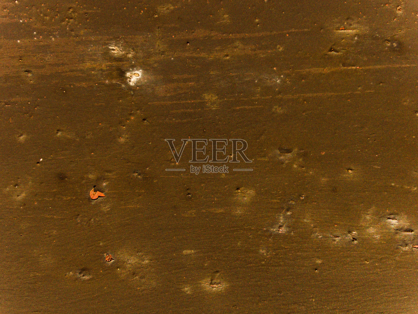 一个有很多孔洞和几块木头的棕色表面照片摄影图片