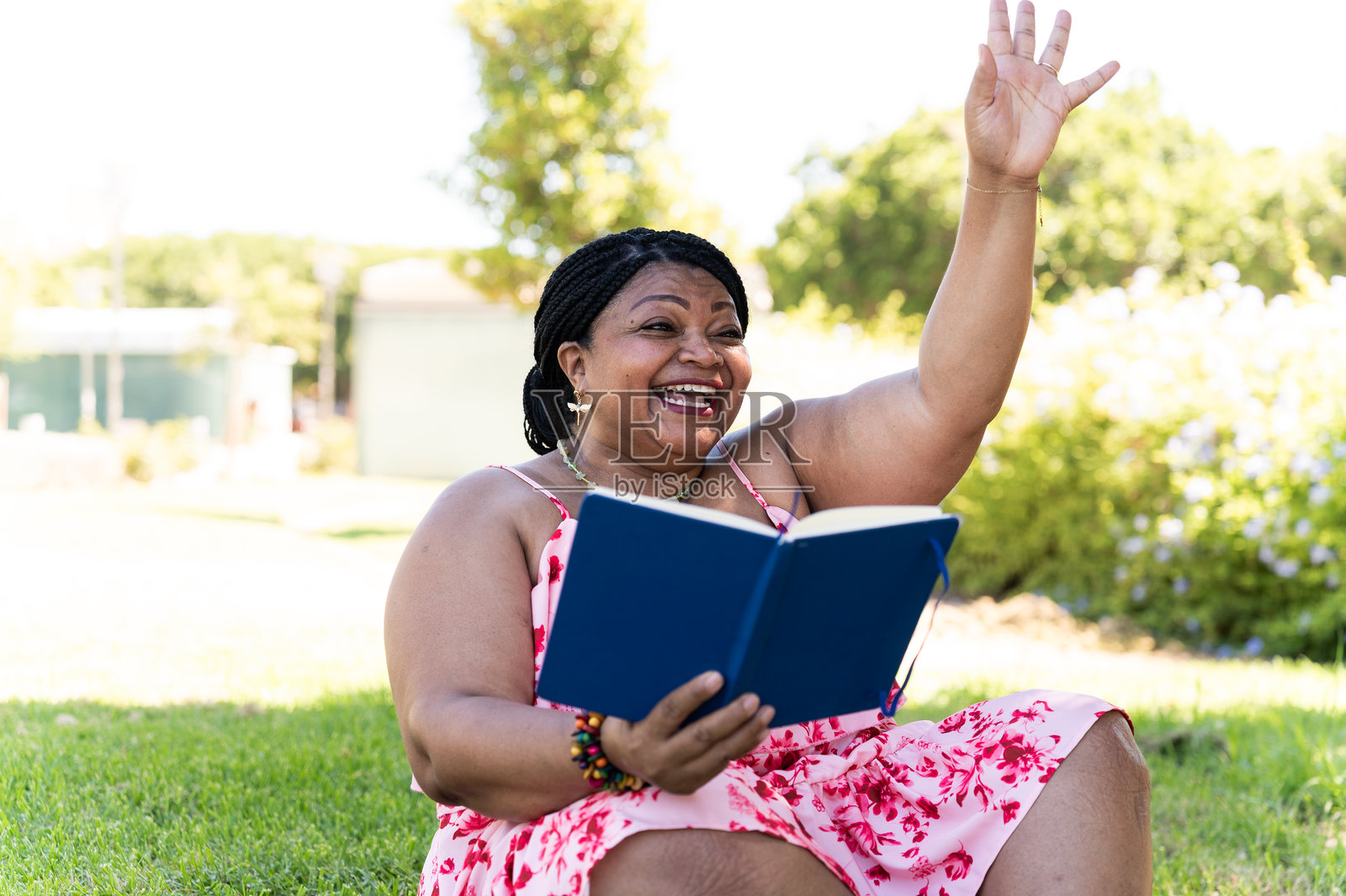 成熟的女性在公园里阅读一本书照片摄影图片