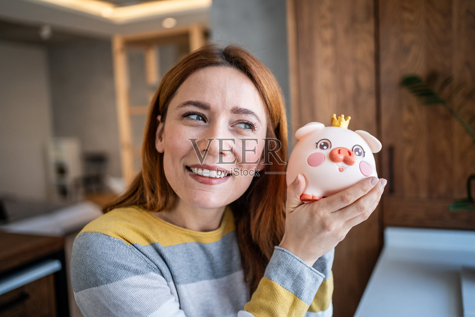 快乐的女人手握储蓄罐,微笑着规划未来的投资照片摄影图片