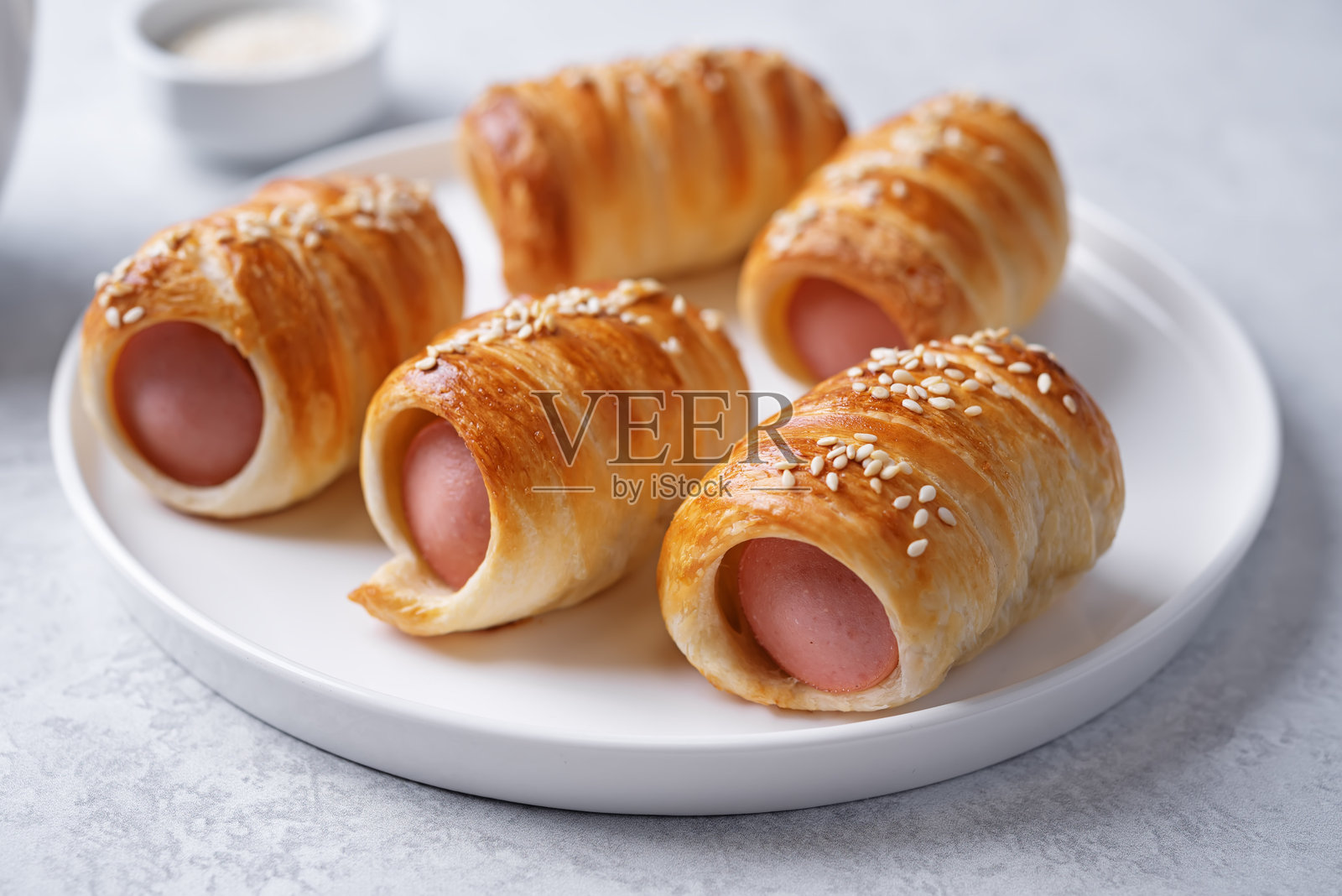 白色背景上的盘子里放着香肠面团迷你热狗面包照片摄影图片