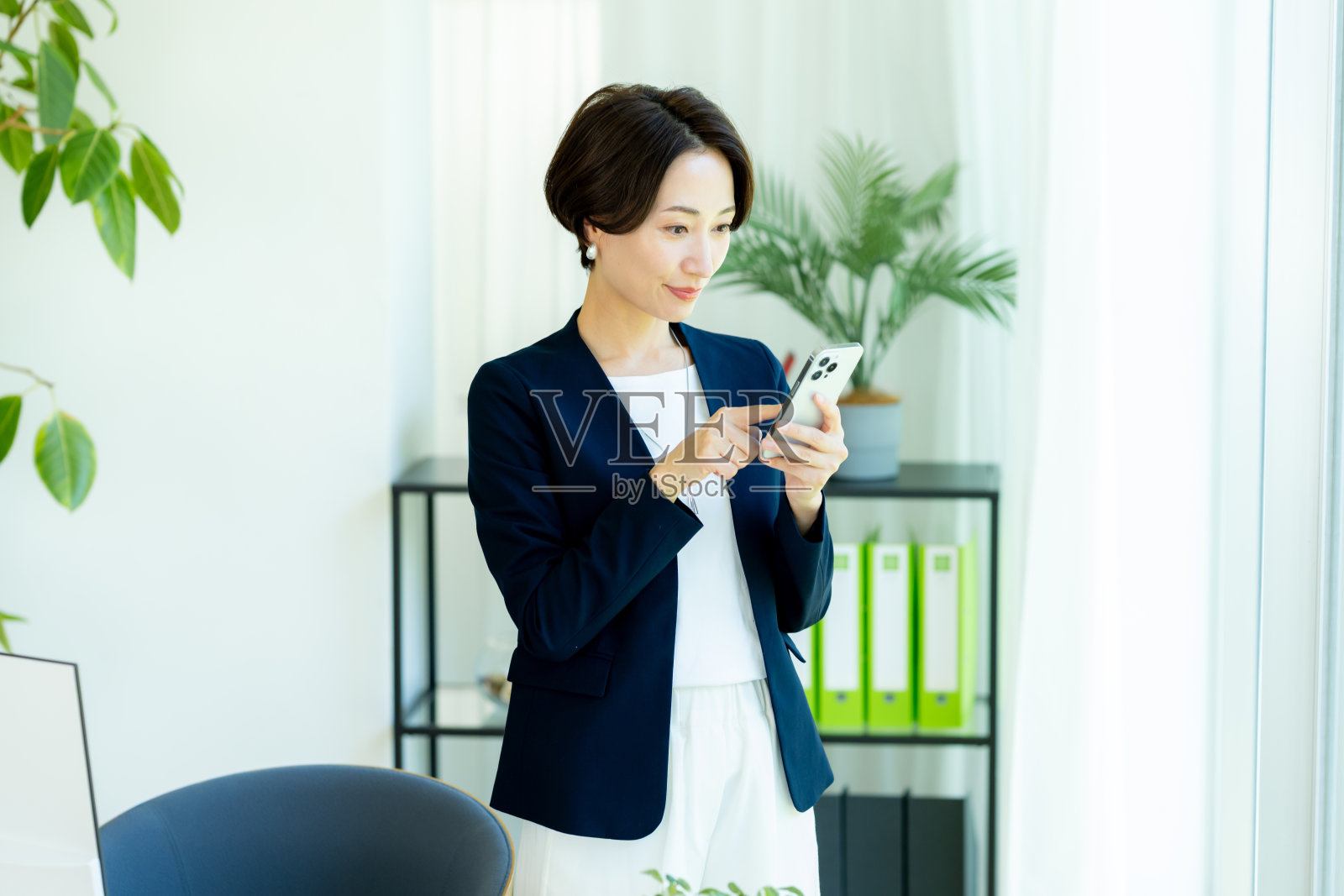 办公室里的职业女性与智能手机照片摄影图片