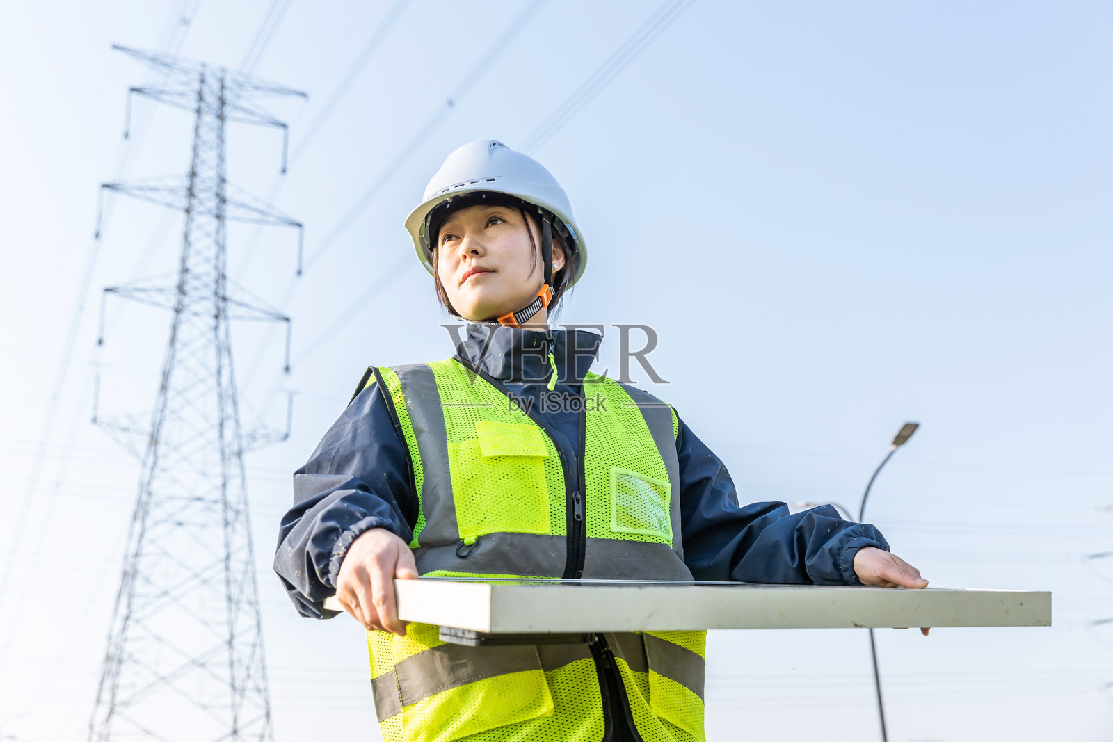 女性工程师在现场手持太阳能电池板工作照片摄影图片