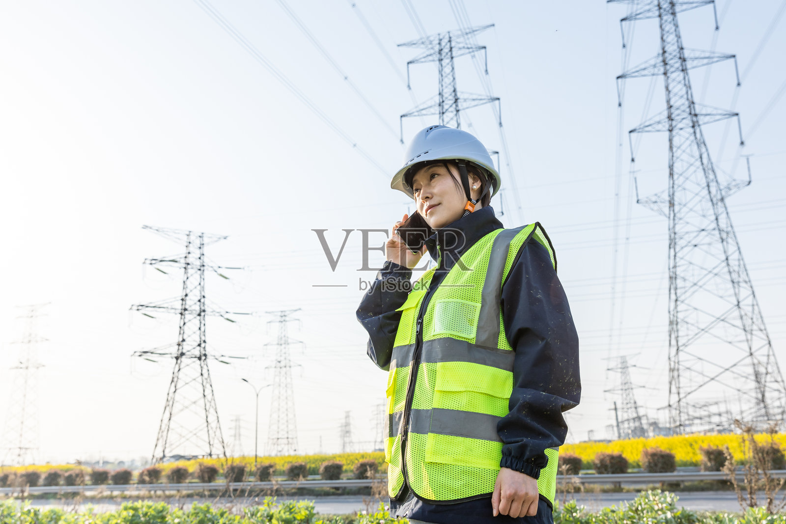 亚洲女性工程师在电力塔下使用智能手机照片摄影图片