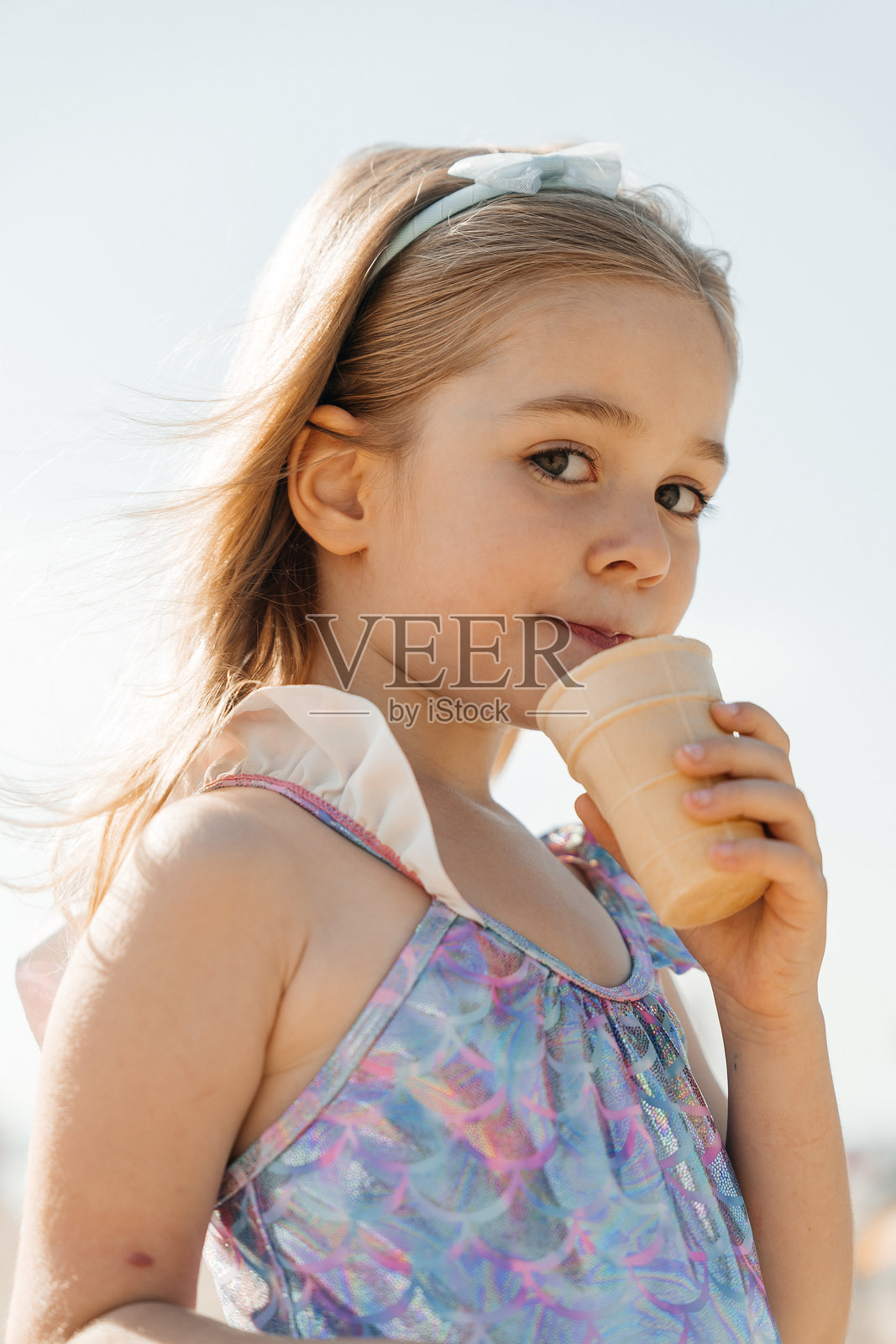 年轻女孩在阳光明媚的海滩上享受冰淇淋照片摄影图片