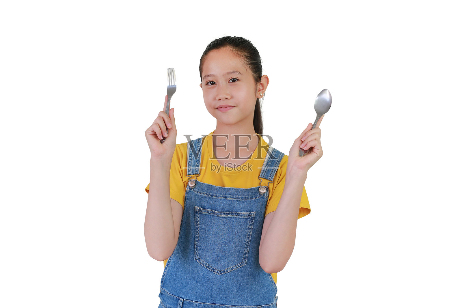 快乐的亚洲女孩手持叉子和勺子,背景为白色摄影棚。准备好享用美餐。照片摄影图片