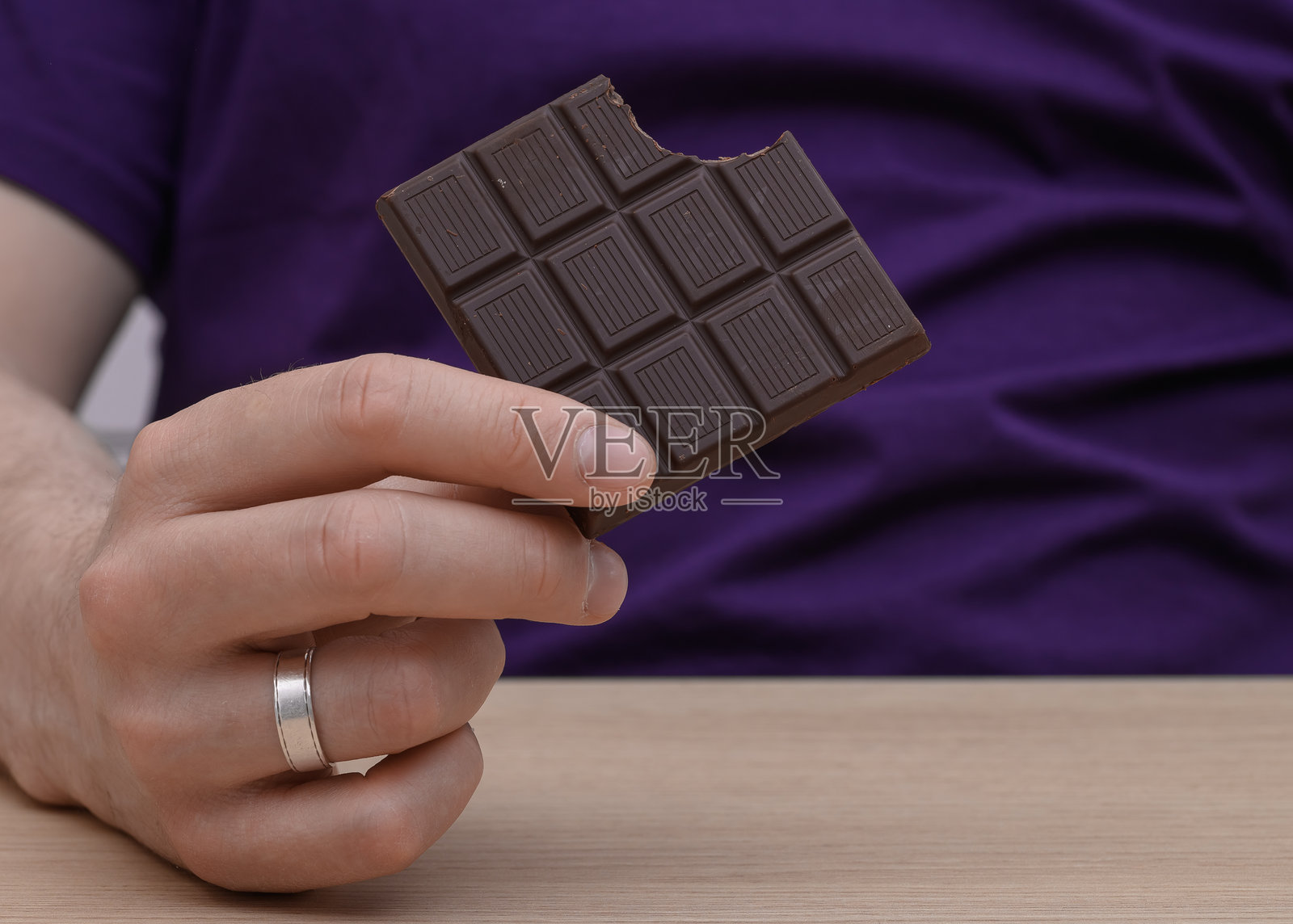 手中握着一块黑巧克力照片摄影图片