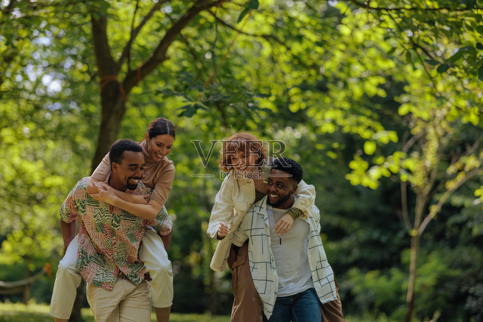 朋友们在公园里享受背着骑的乐趣照片摄影图片