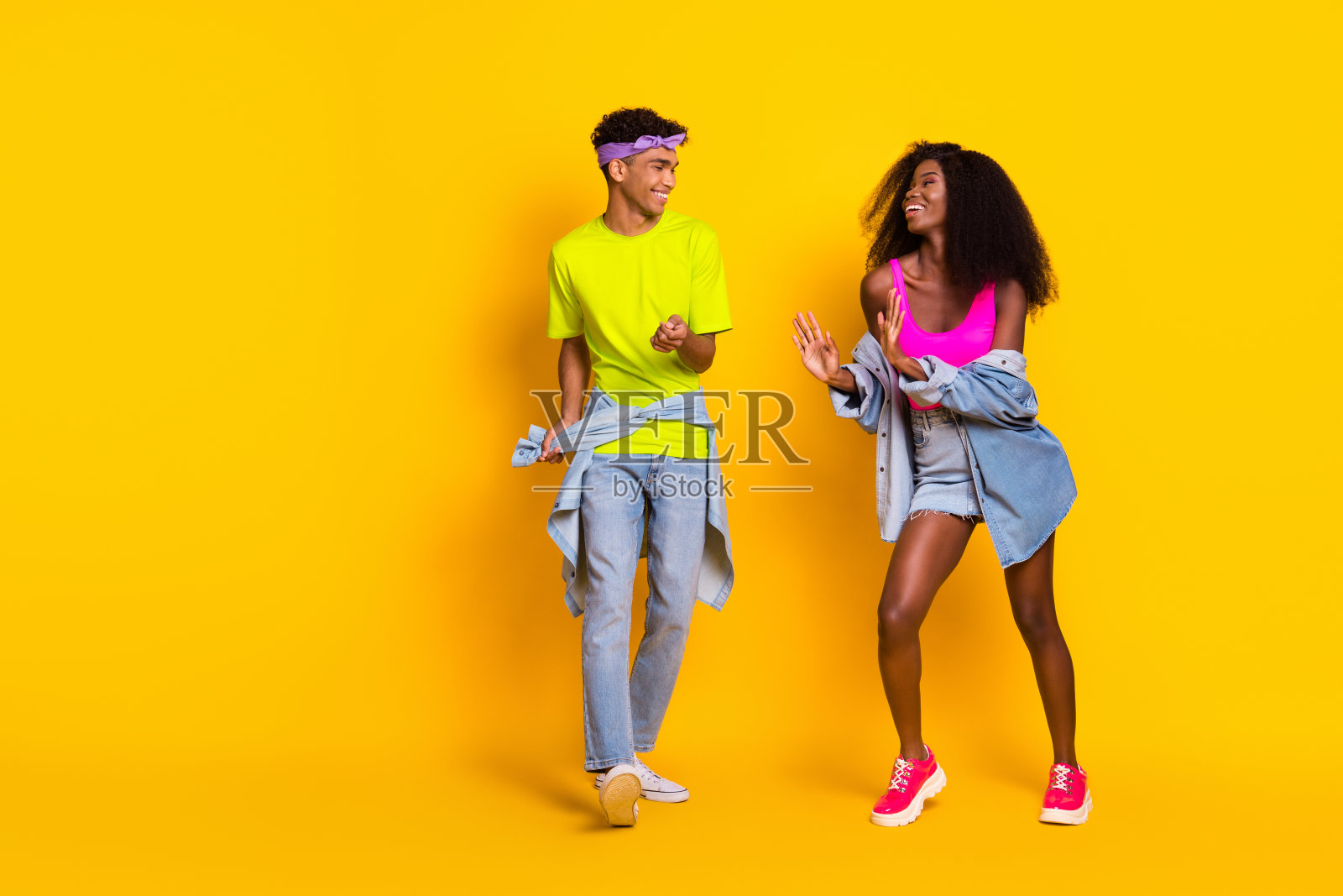 充满魅力的快乐情侣在明亮的黄色背景下跳舞,享受闲暇时光的全身视图照片摄影图片