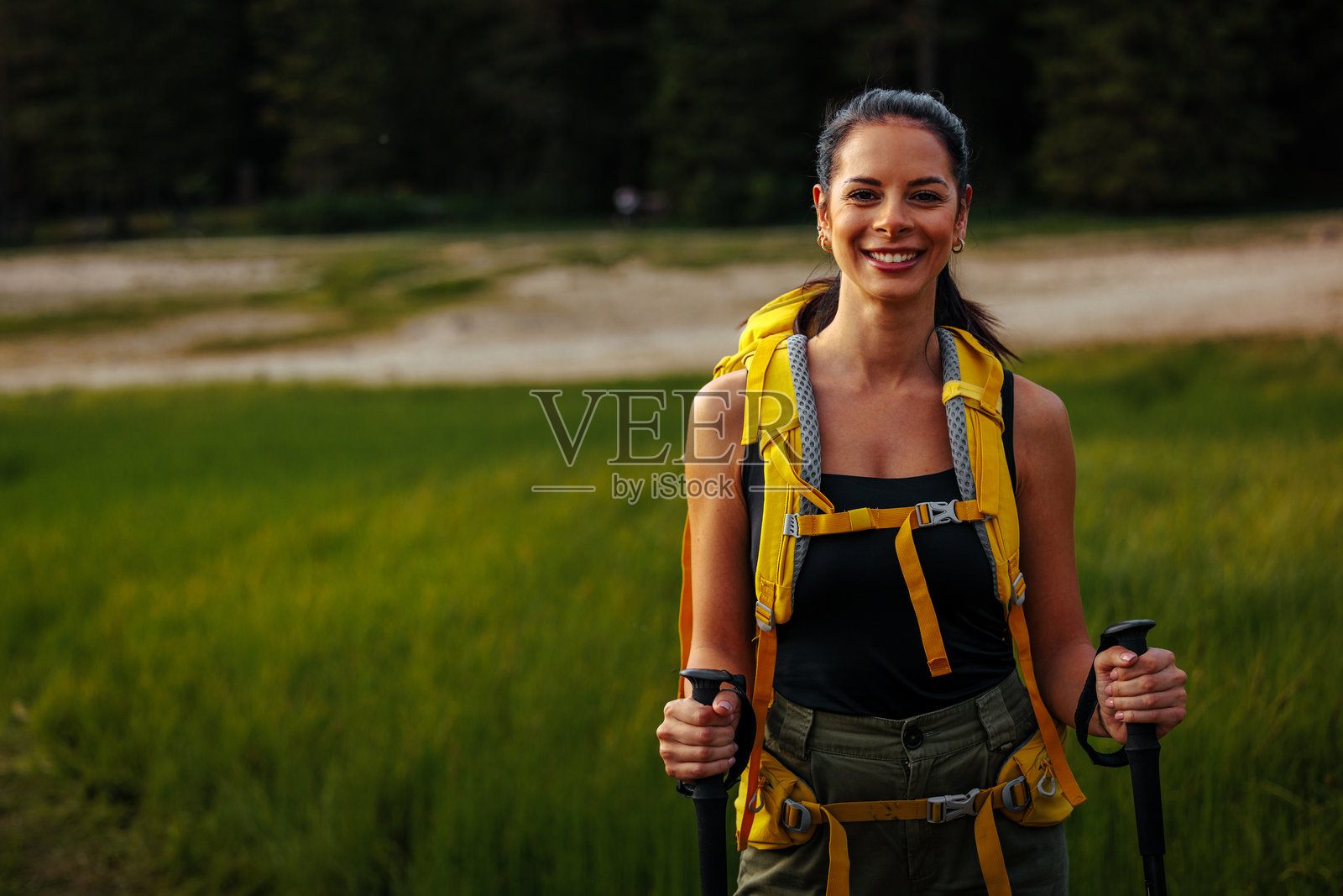 微笑着摆姿势拍照的女性徒步旅行者照片摄影图片
