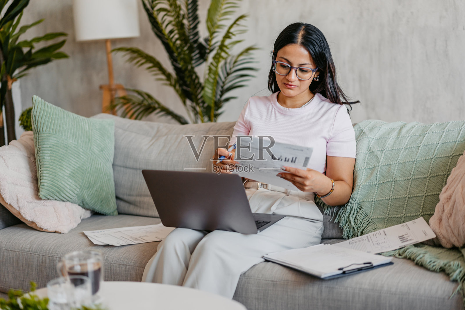 年轻印度女性在家用笔记本电脑查看财务情况照片摄影图片