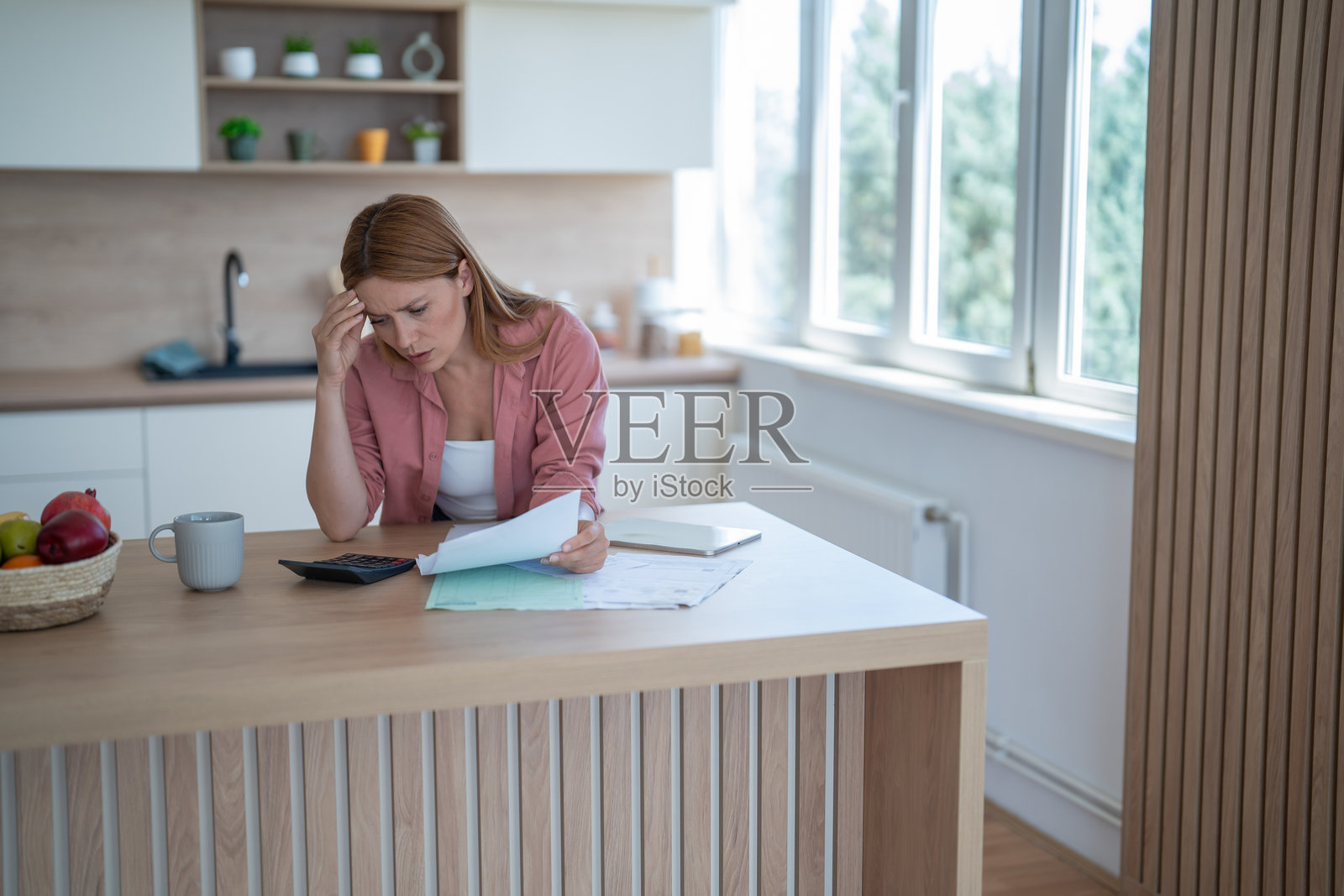 在现代厨房中,感到压力的女性正在管理家庭财务照片摄影图片