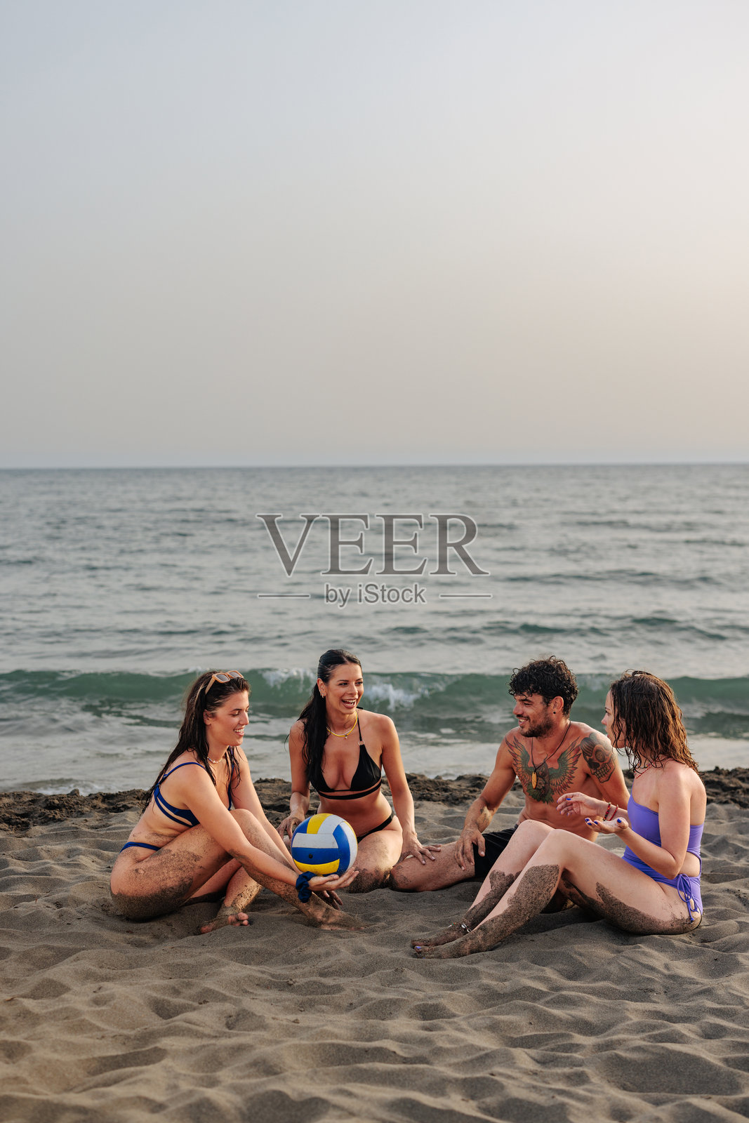 四个年轻人在海滩上照片摄影图片