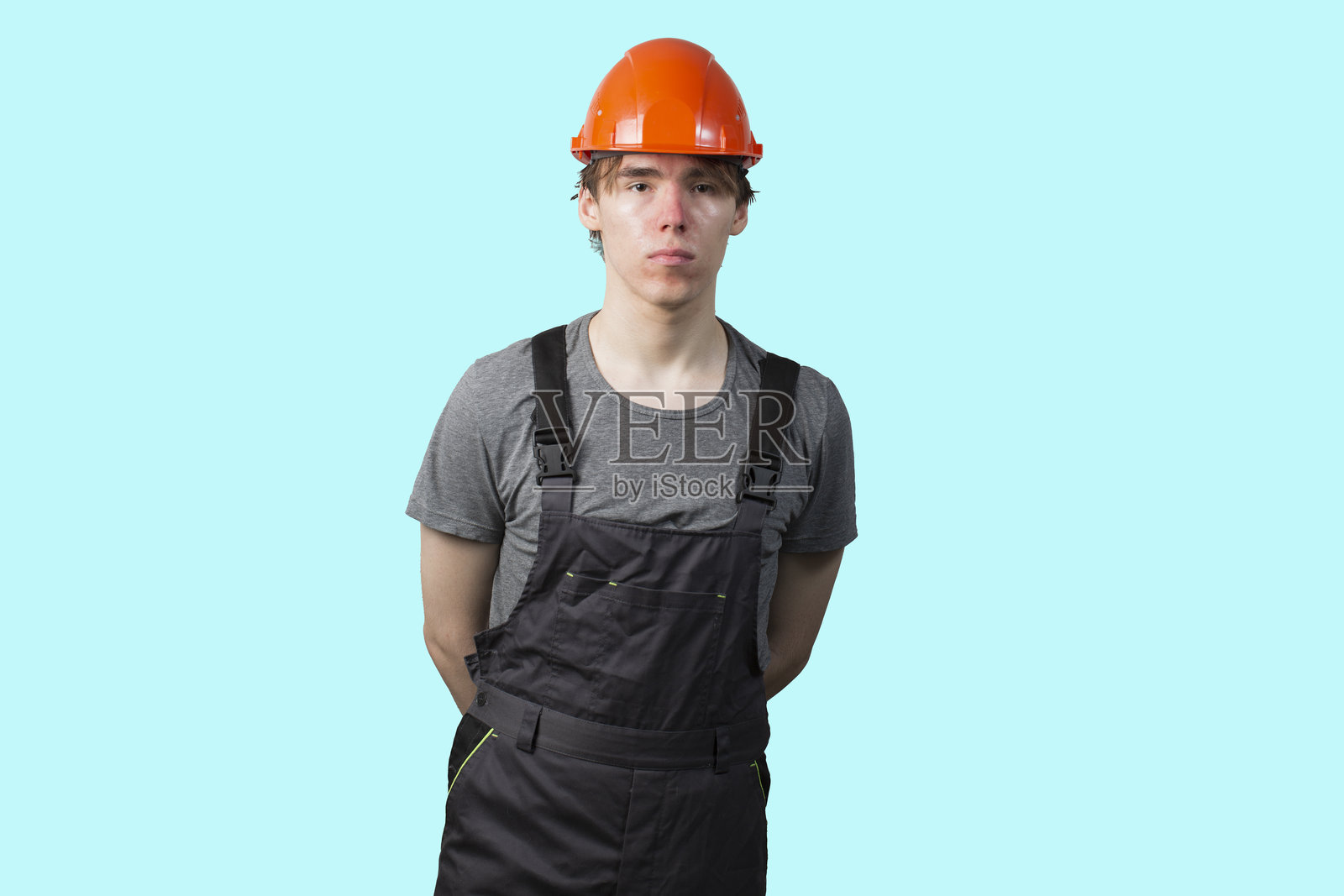 一个戴着橙色安全帽的年轻人。孤立。照片摄影图片