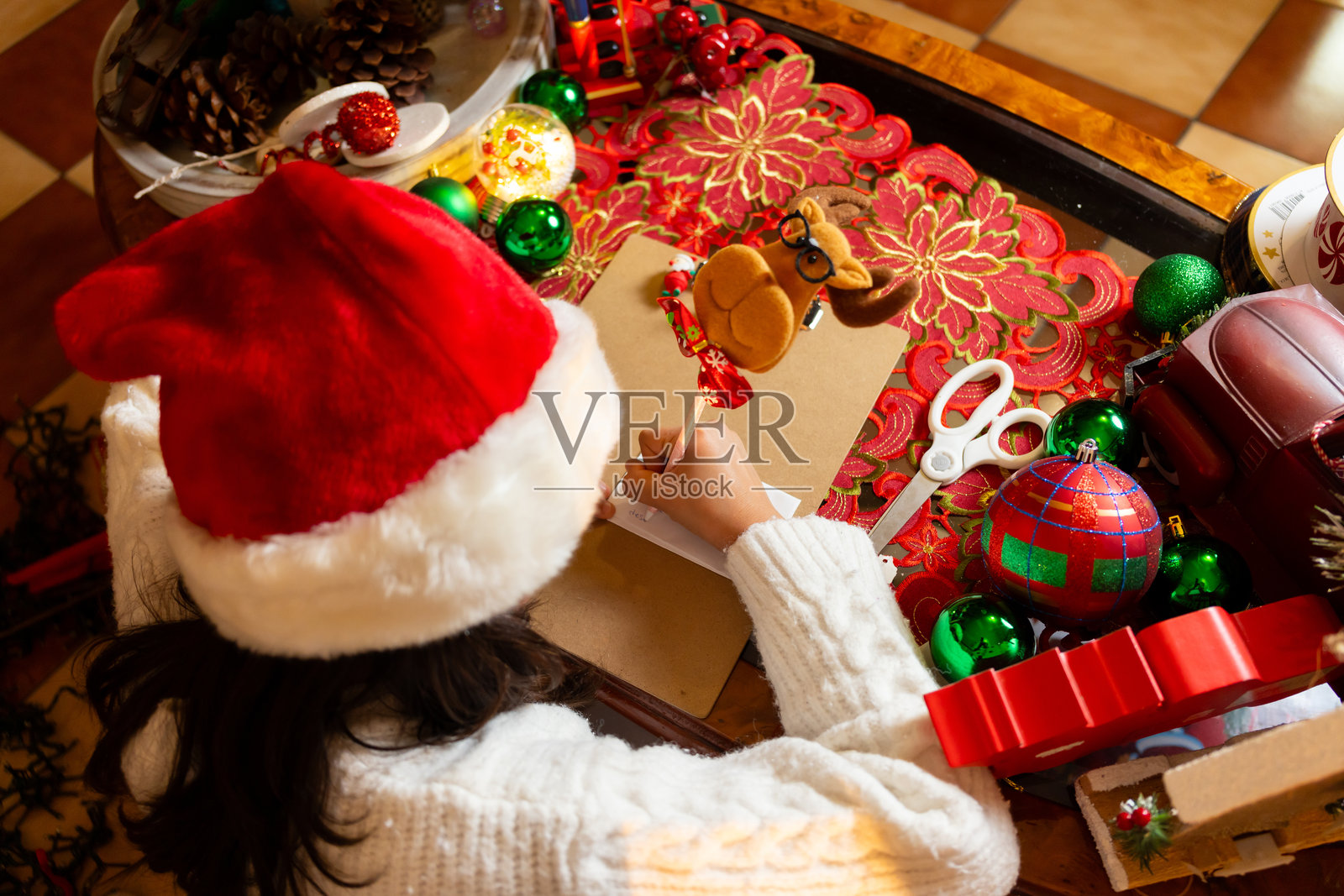 女孩从上方写信给圣诞老人。照片摄影图片