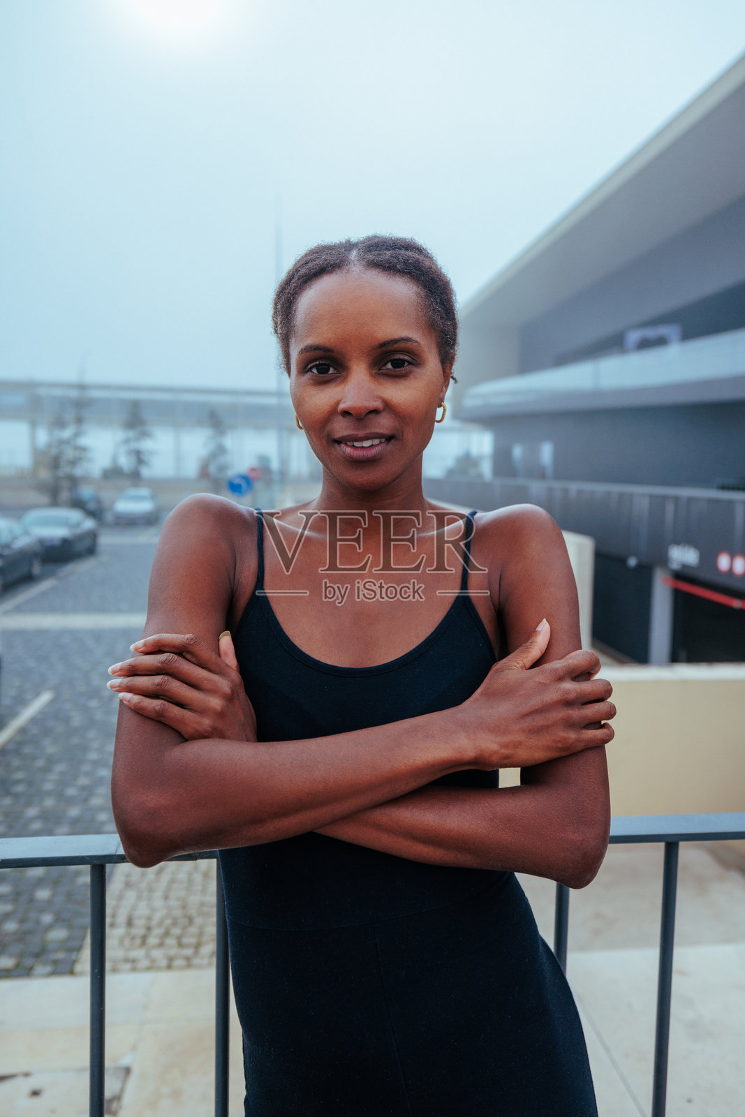 自信的健身教练在户外摆姿势,双臂交叉。照片摄影图片