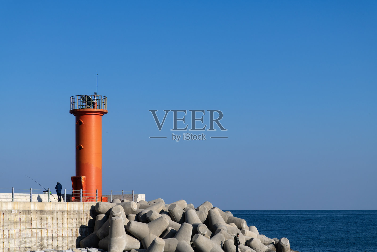 海边海堤上的灯塔照片摄影图片