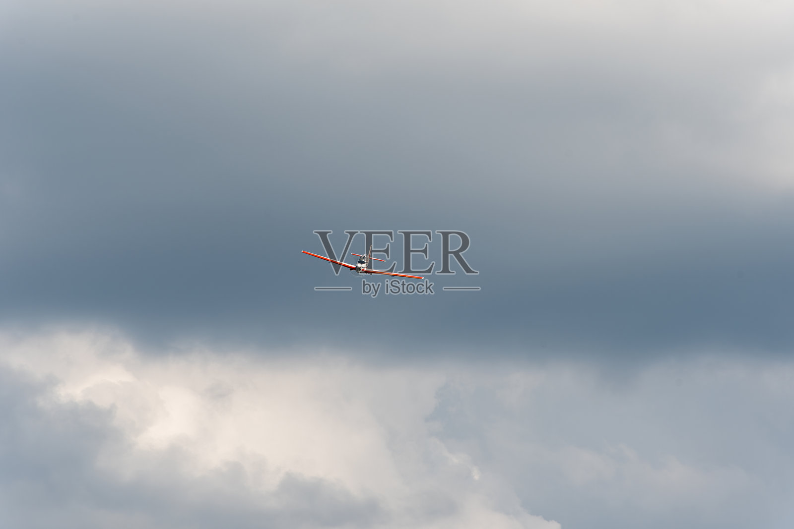 飞机正面在云层中飞行,背景是戏剧性的天空。照片摄影图片