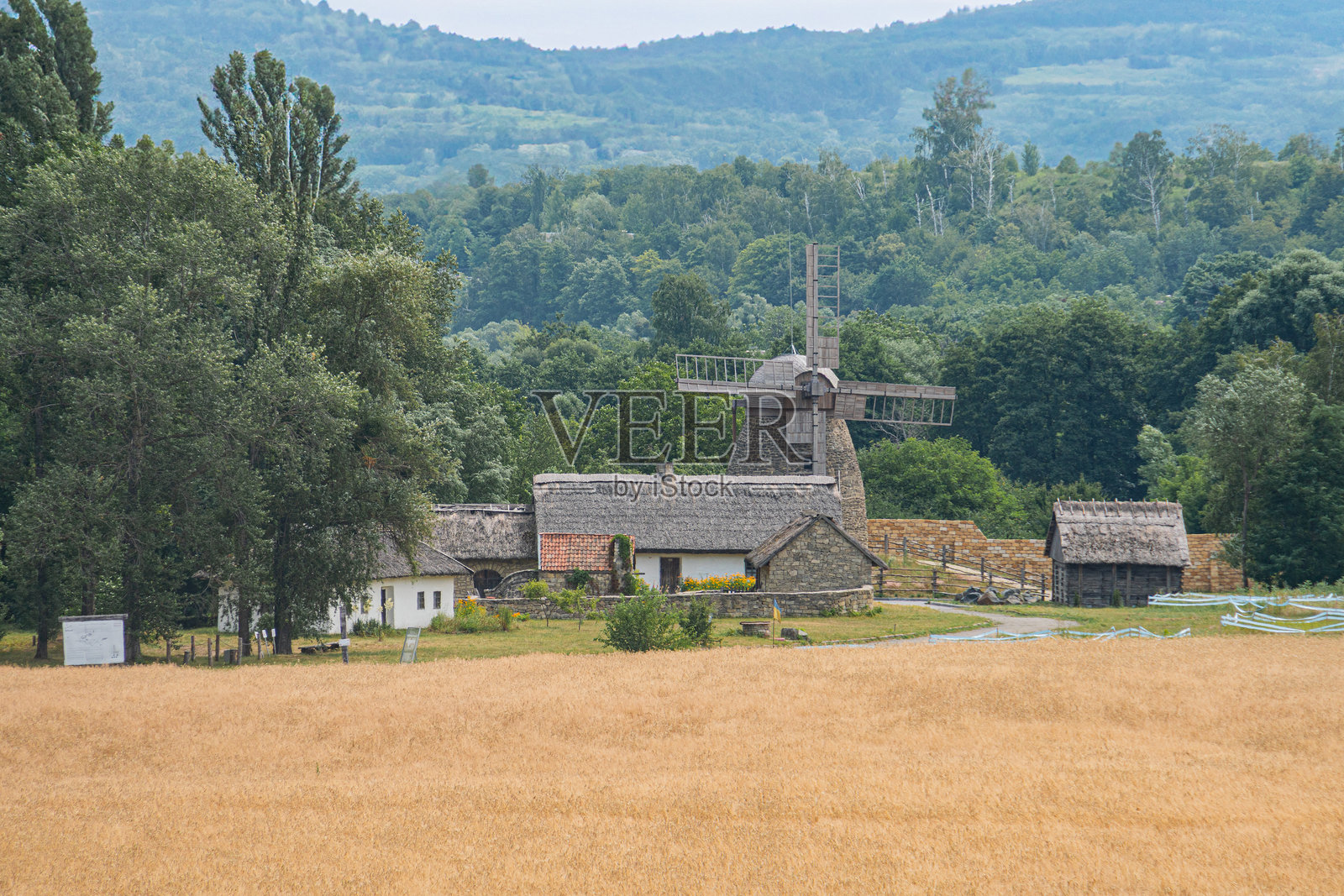 中欧乡村村庄,木制风车,农场建筑,干燥的景观,土色调,宁静,永恒,柔和的阴影,清晨或傍晚的光线,写实风格,远景透视照片摄影图片