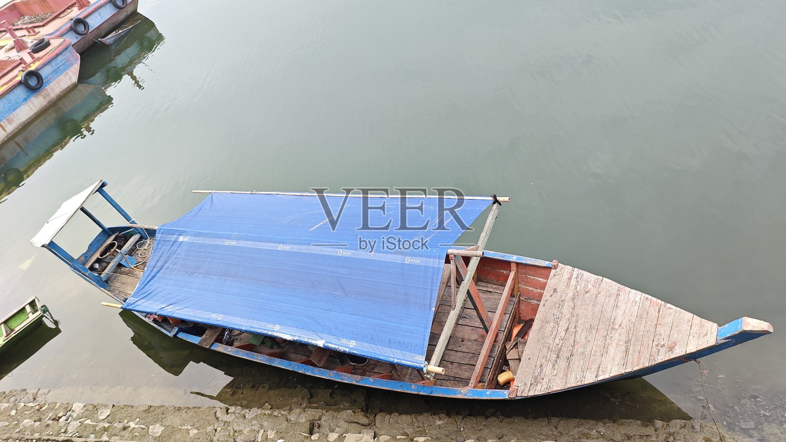 停靠在泥泞海滩上的传统木制渔船照片摄影图片