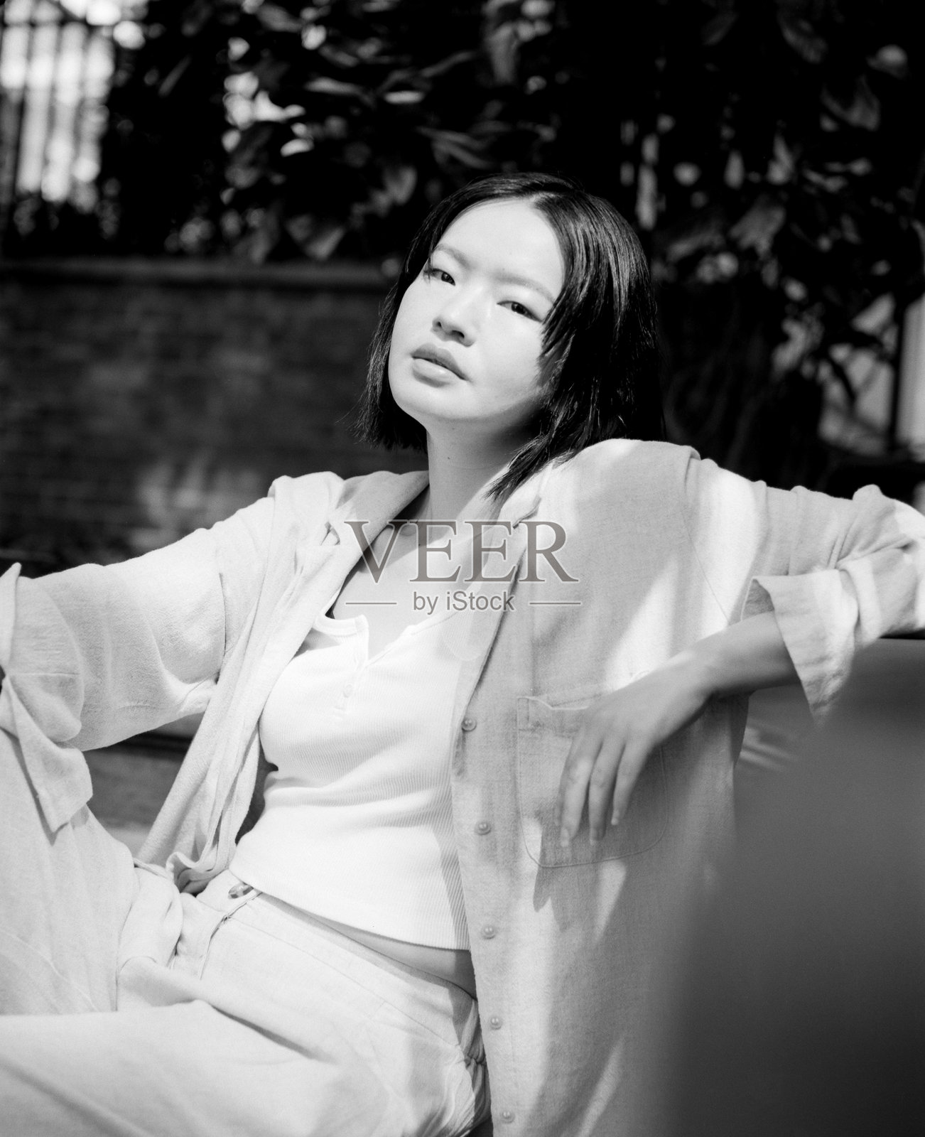 年轻亚洲女性在热带花园中以单色风格摆姿势照片摄影图片