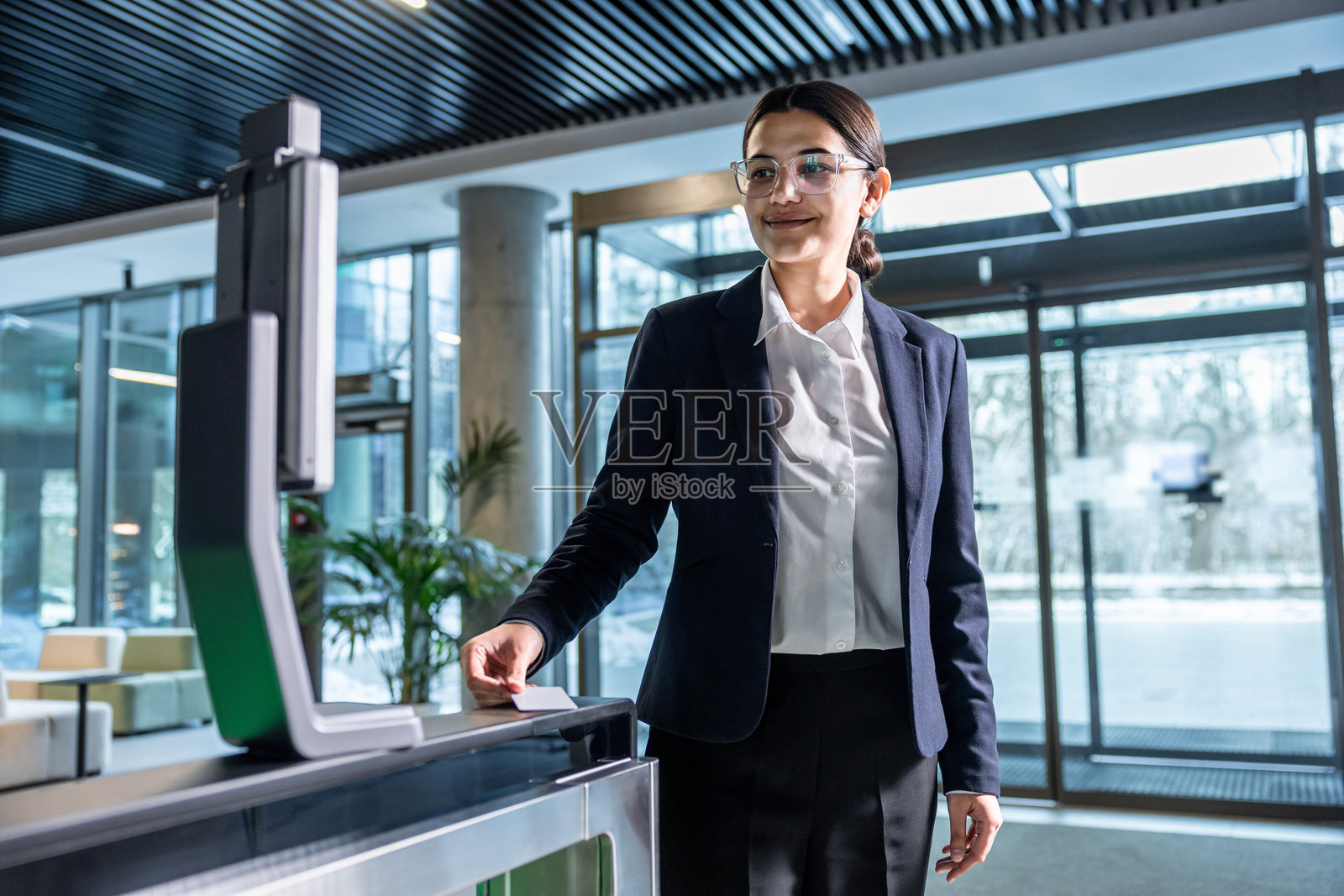 优雅的女商人在商务中心的安检口旁站着照片摄影图片