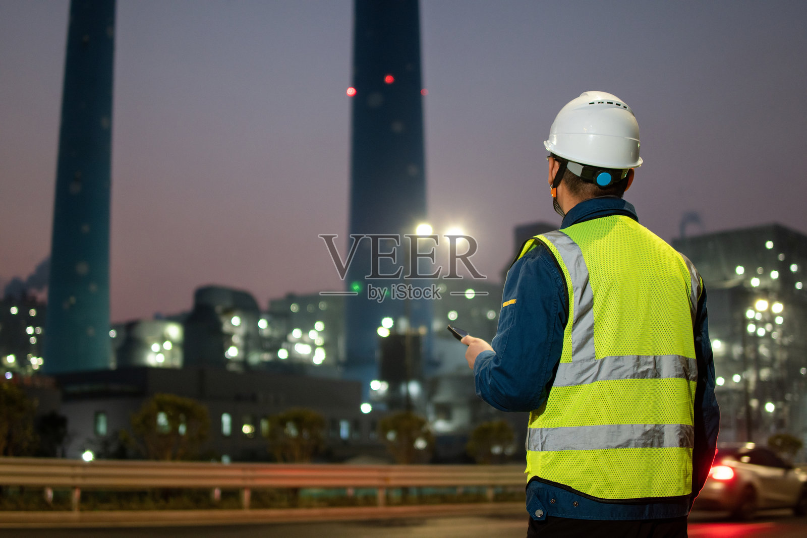 中年男性工程师在火力发电厂使用智能手机照片摄影图片